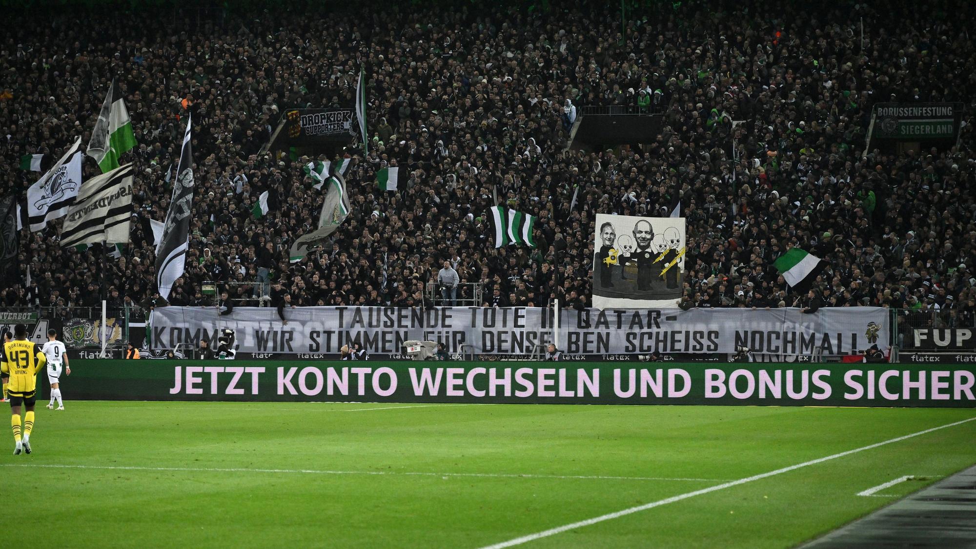 Gladbach-Fans halten ein Banner gegen die WM-Vergabe nach Saudi-Arabien nach oben.