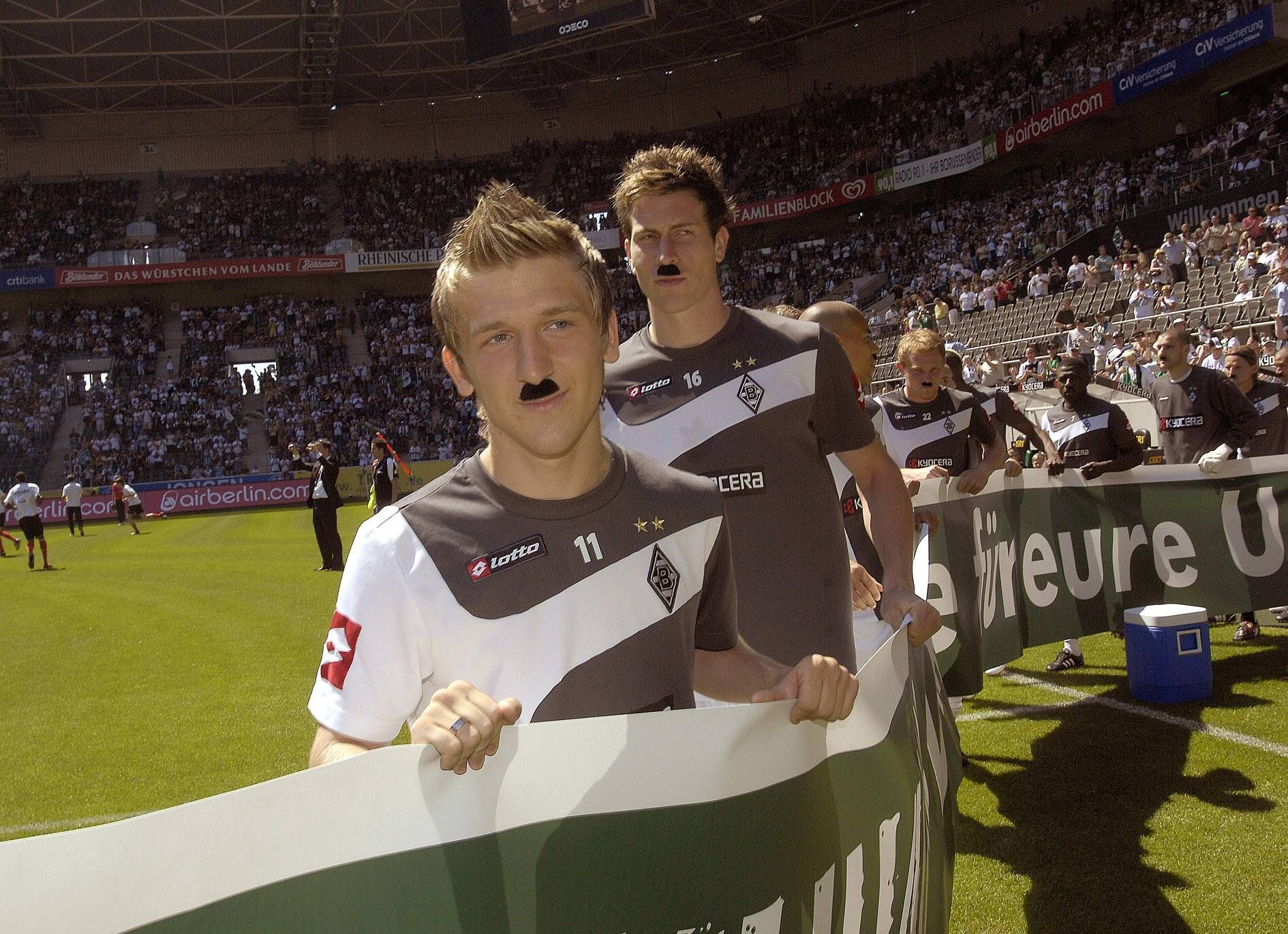 Profis von Borussia Mönchengladbach mit aufgeklebtem Schnurrbart bei der Aufstiegsfeier.