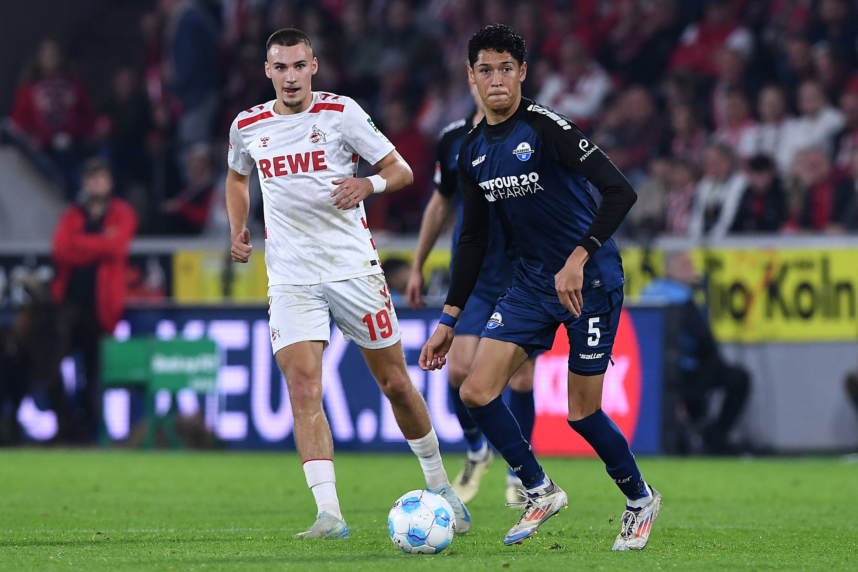 Paderborns Santiago Castaneda führt den Ball im Spiel beim 1. FC Köln. FC-Profi Tim Lemperle verfolgt ihn.