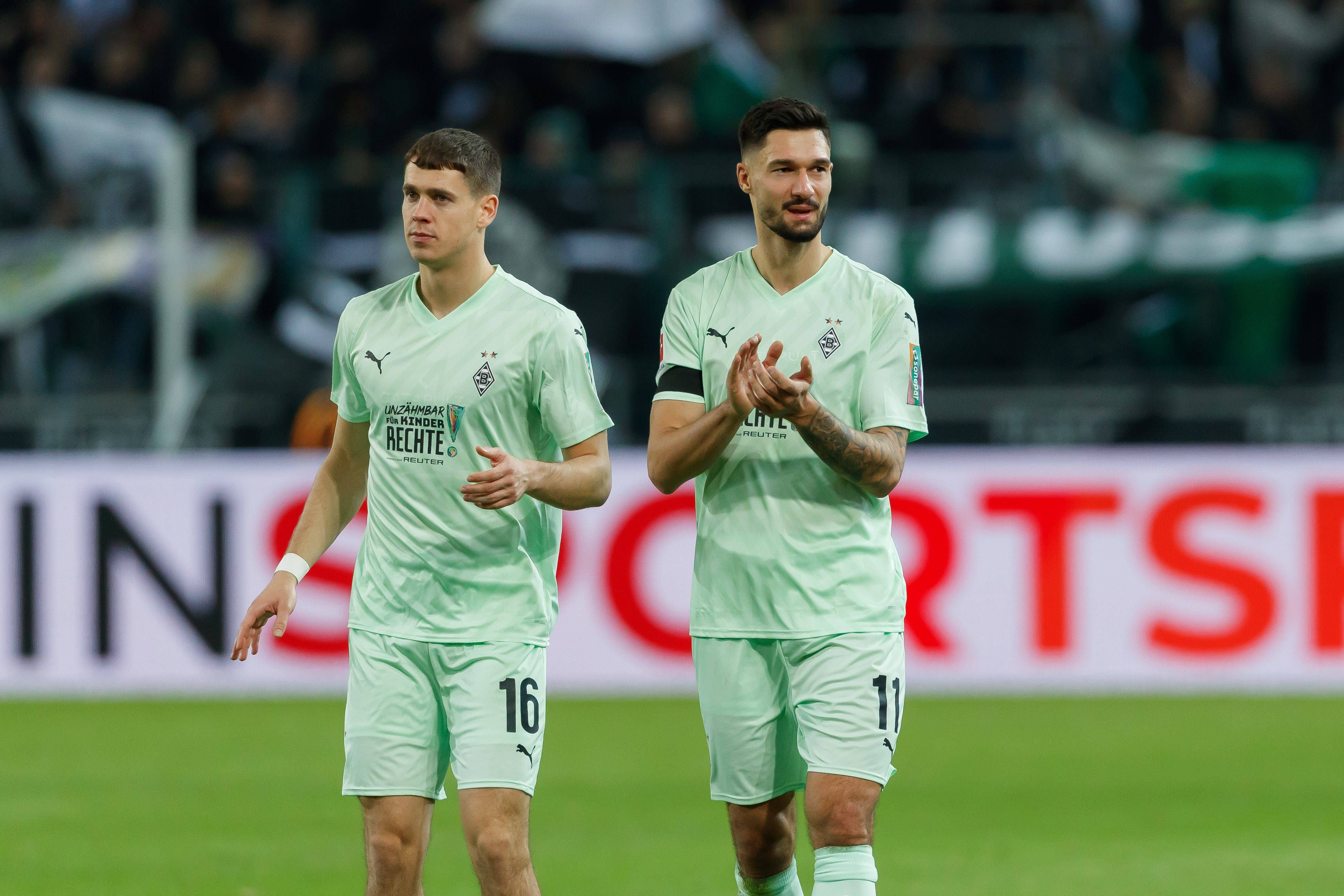 Die Gladbach-Profis Philipp Sander und Tim Kleindienst laufen nach dem Spiel gegen den FC St. Pauli nebeneinander über den Platz.