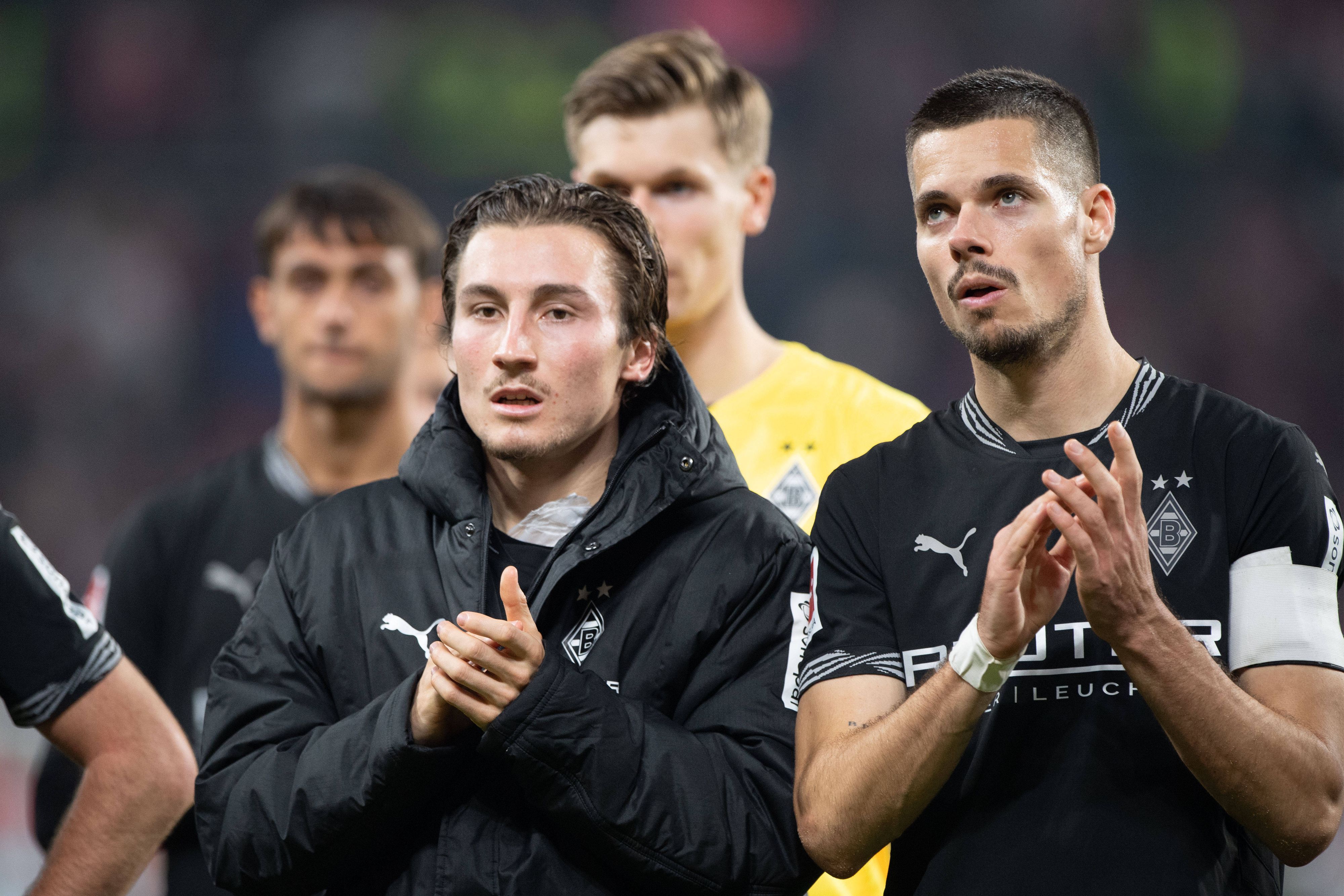 Rocco Reitz und Julian Weigl klatschen den Fans entgegen.