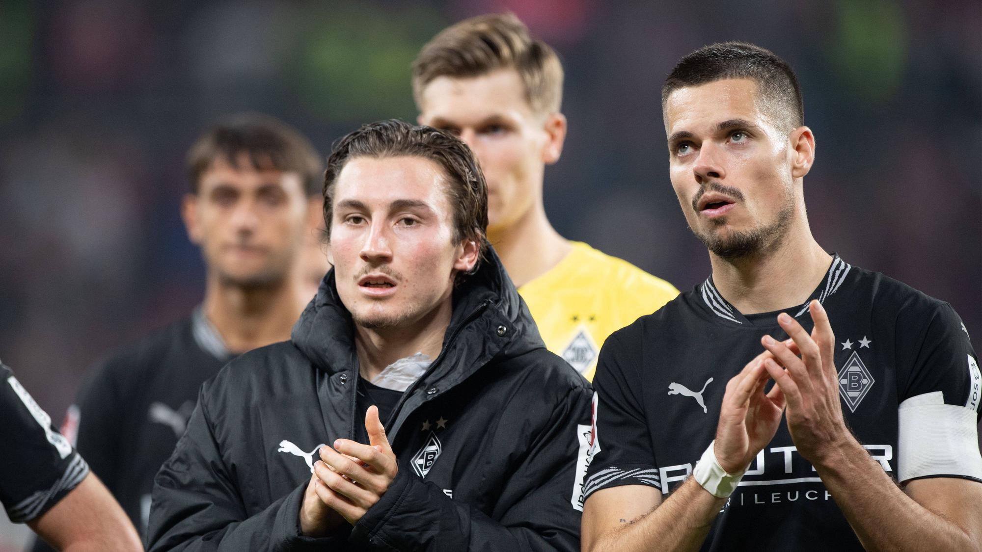 Rocco Reitz und Julian Weigl klatschen den Fans entgegen.
