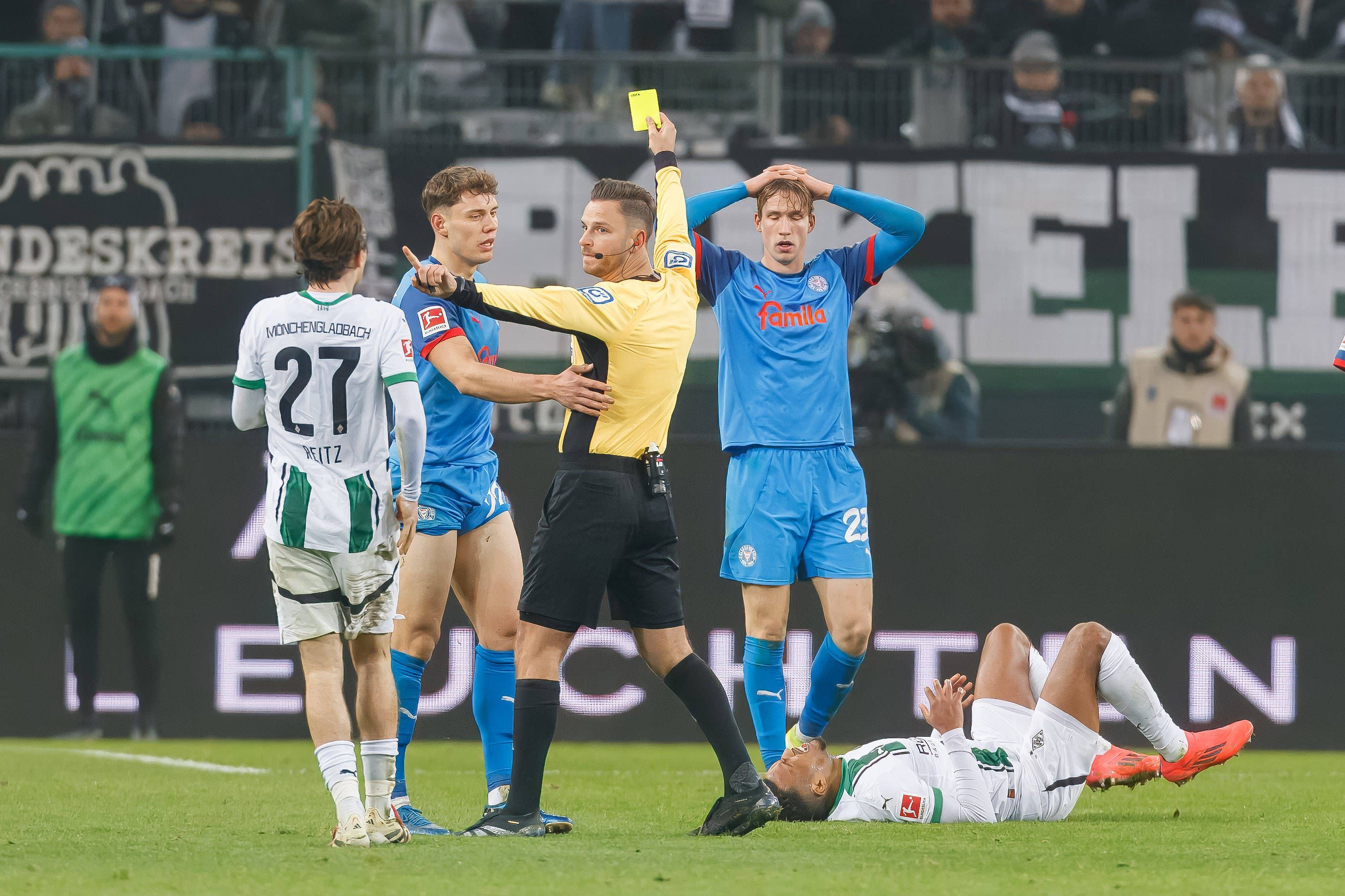 Daniel Schlager zeigt einem Spieler von Holstein Kiel die Gelbe Karte.