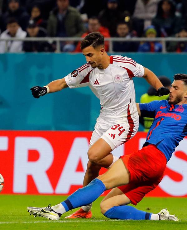 Olympiakos-Profi Charalampos Kostoulas wird im Europa-League-Spiel bei FCSB Bukarest von seinem Gegenspieler abgegrätscht.