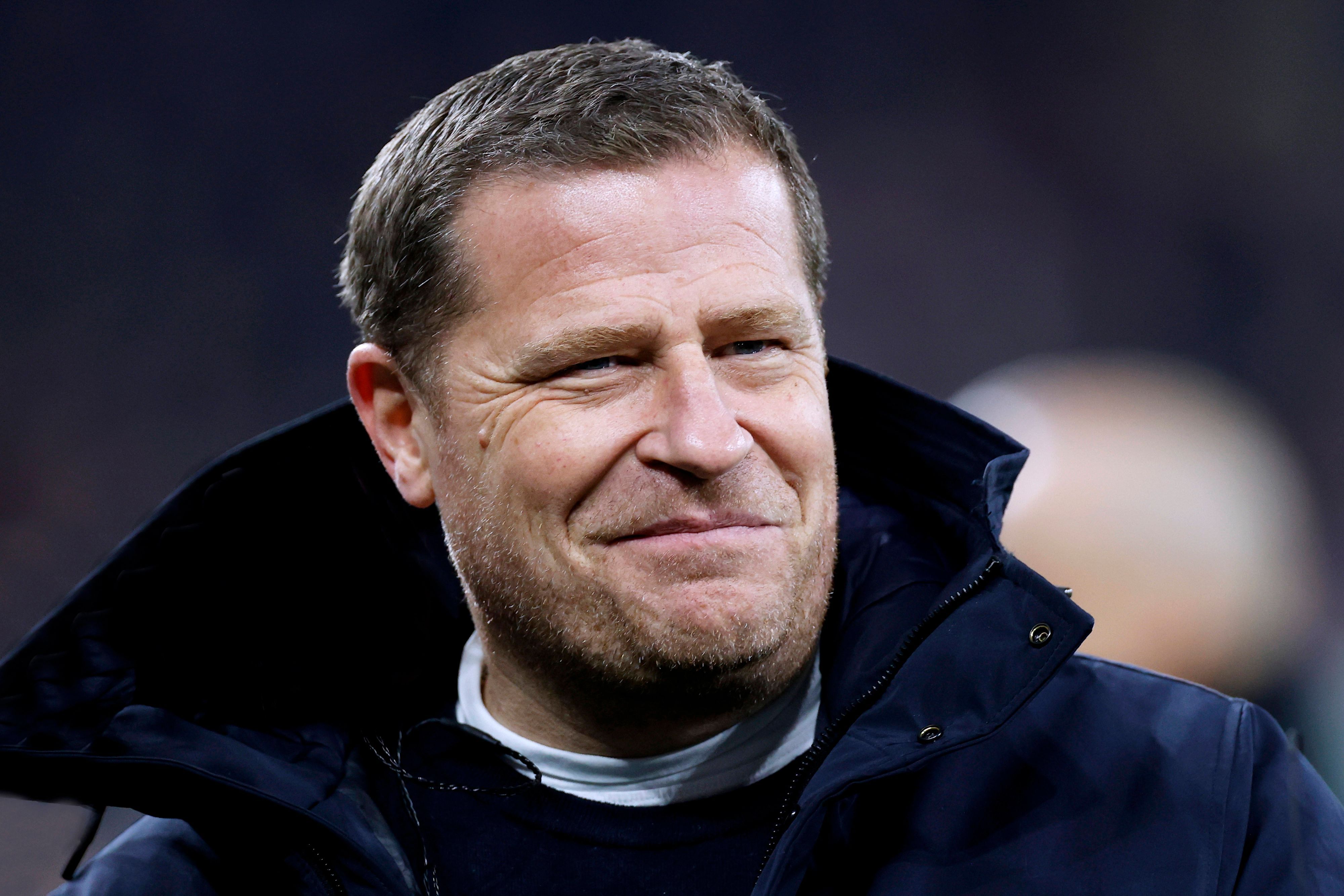 FC Bayern Münchens Sport-Vorstand Max Eberl steht beim Champions-League-Spiel seines FC Bayern München gegen Schachtar Donezk im Stadion und lächelt.