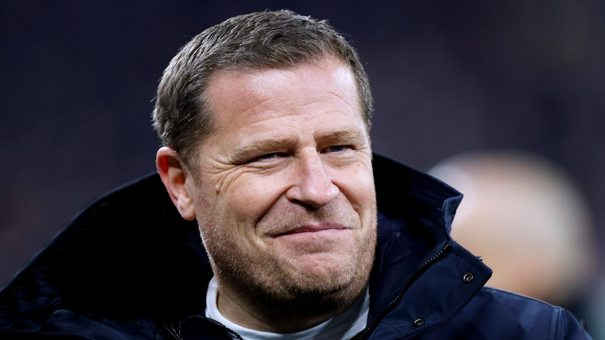 FC Bayern Münchens Sport-Vorstand Max Eberl steht beim Champions-League-Spiel seines FC Bayern München gegen Schachtar Donezk im Stadion und lächelt.