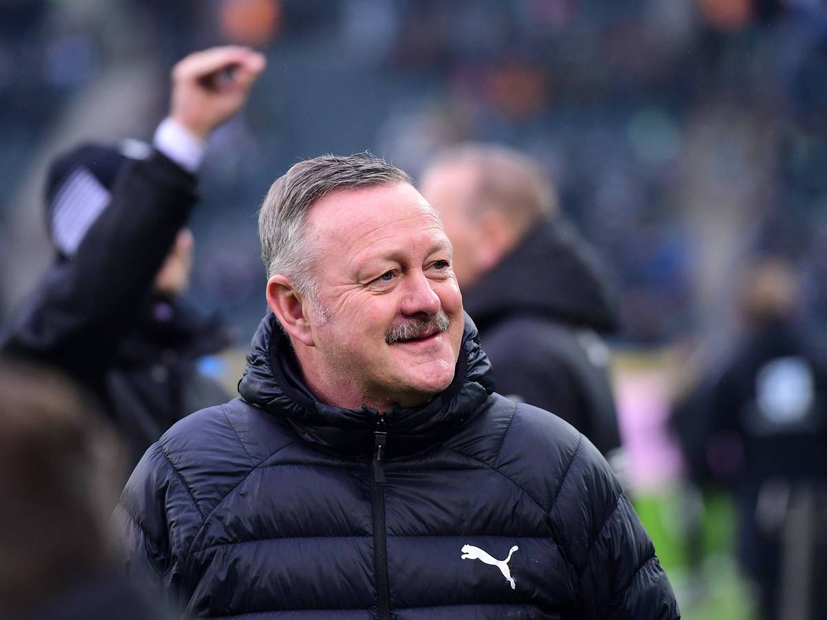 Roland Virkus grinst vor einem Spiel in der Bundesliga.