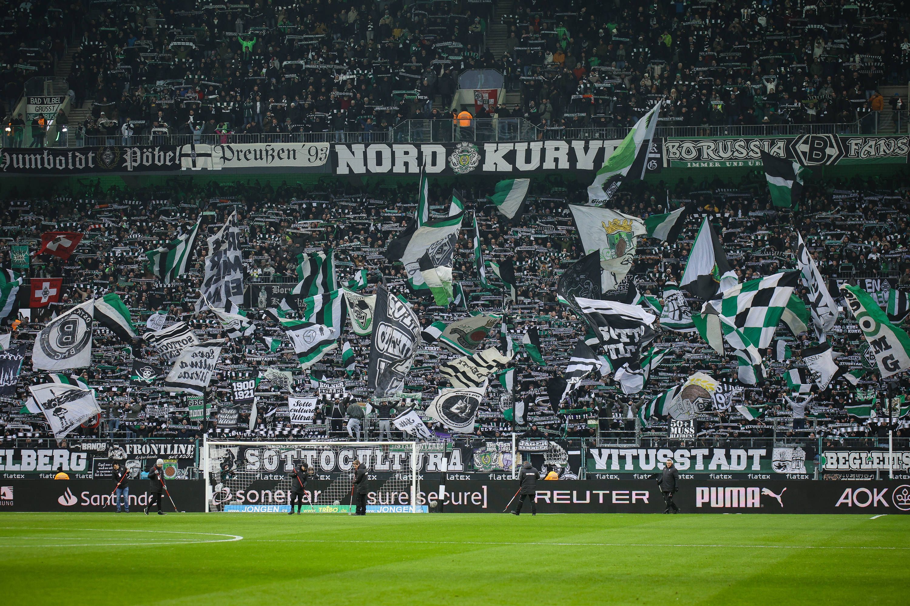 Die Fans von Borussia Mönchengladbach schwenken in der Nordkurve beim Bundesliga-Spiel gegen Holstein Kiel ihre Fahnen.