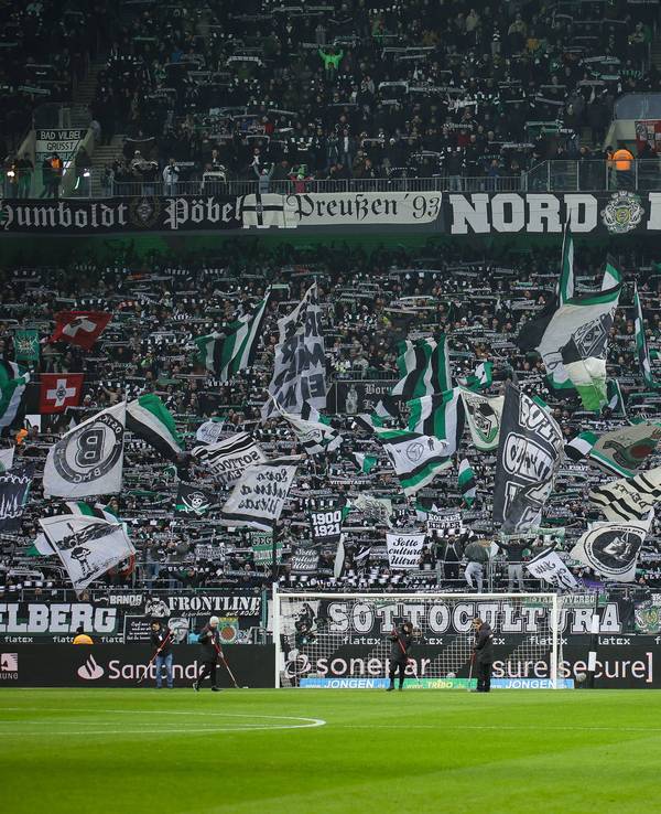 Die Fans von Borussia Mönchengladbach schwenken in der Nordkurve beim Bundesliga-Spiel gegen Holstein Kiel ihre Fahnen.