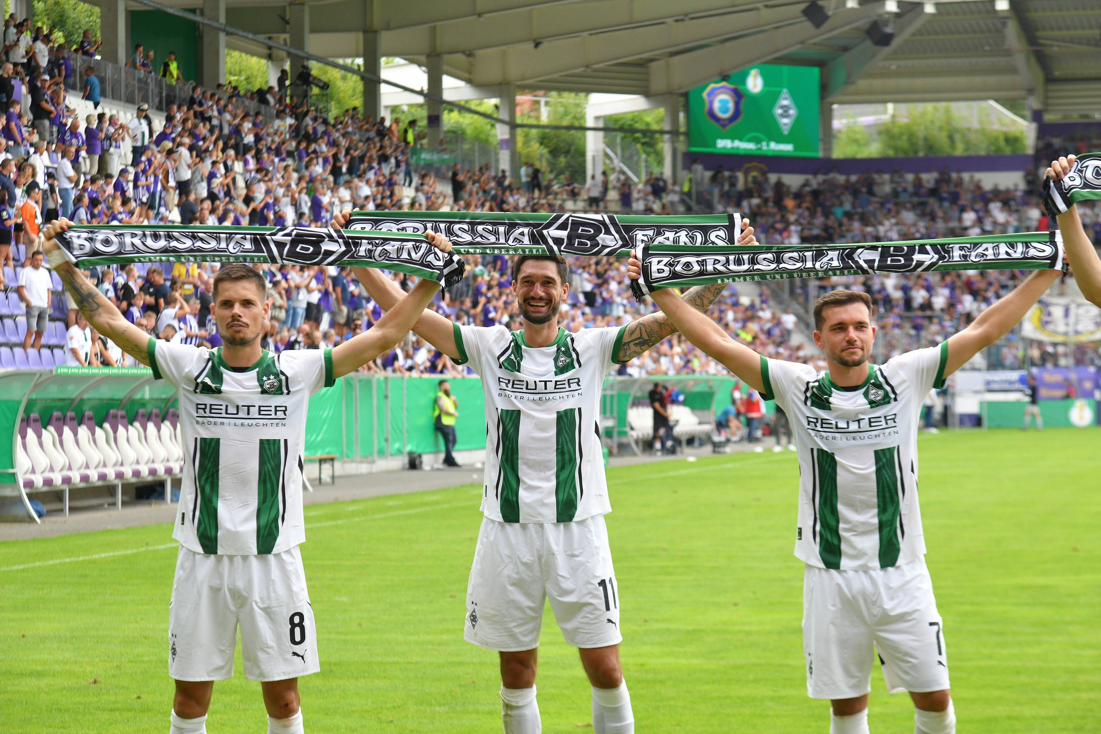 Gladbach-Spieler feiern mit Schals in der Hand vor den Fans in Aue.