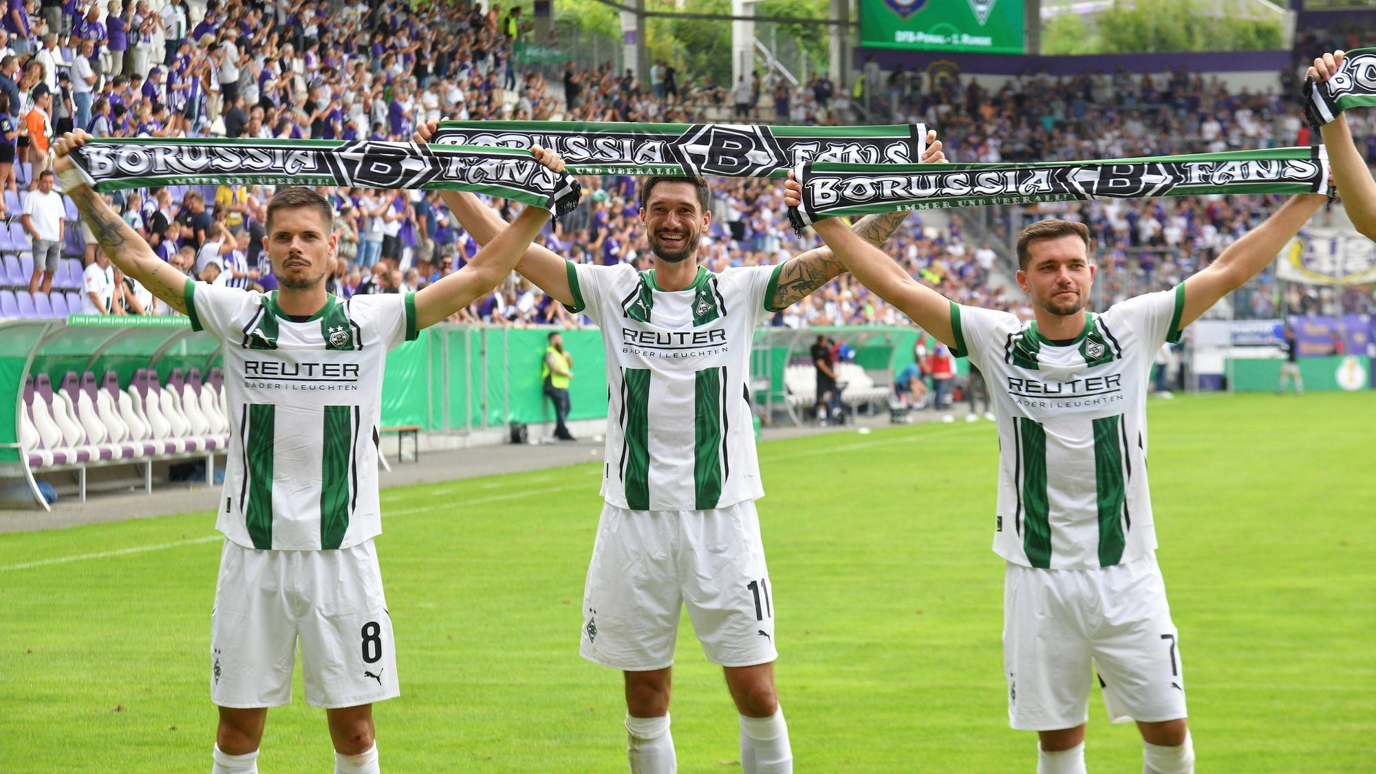 Gladbach-Spieler feiern mit Schals in der Hand vor den Fans in Aue.