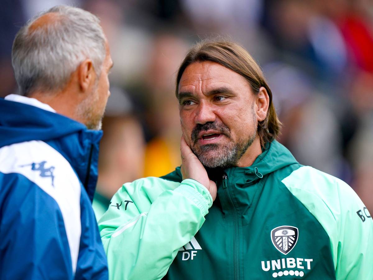 Daniel Farke unterhält sich in Regenjacke mit Adi Hütter am Seitenrand.