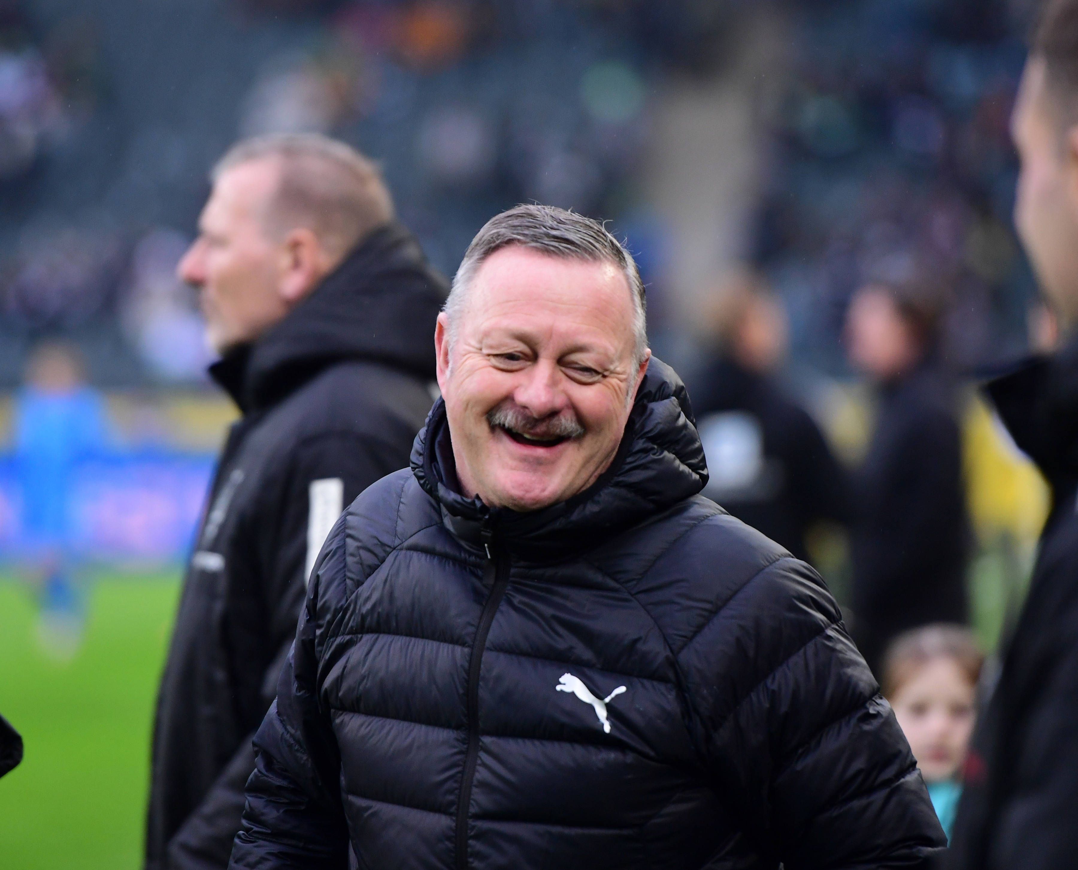 Roland Virkus lächelt vor einem Spiel.