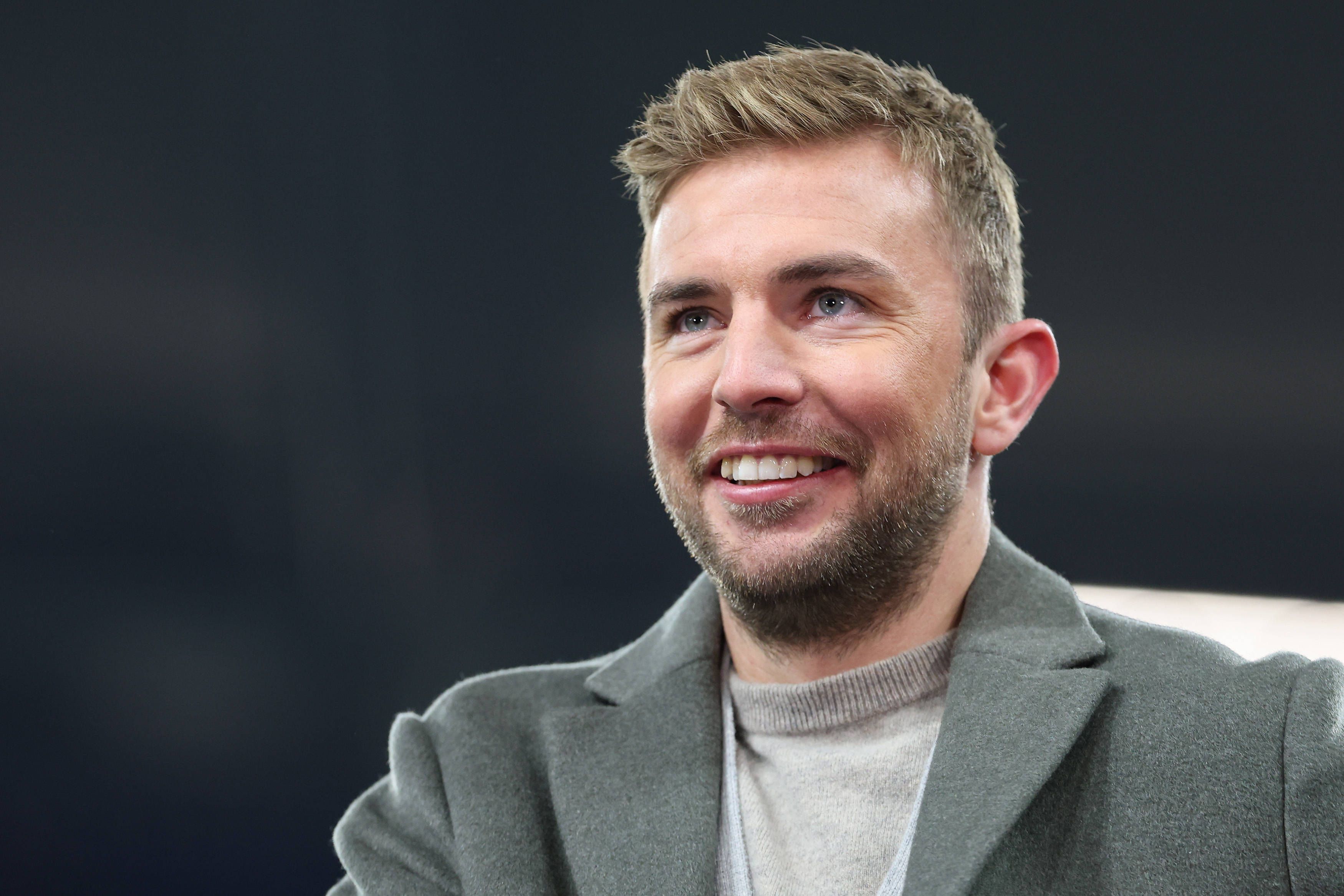 TV-Experte Christoph Kramer steht beim Champions-League-Spiel Schachtar Donezk gegen den FC Bayern München im Stadion und lächelt.
