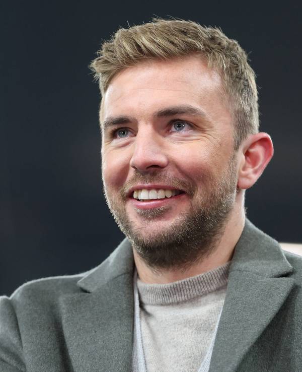 TV-Experte Christoph Kramer steht beim Champions-League-Spiel Schachtar Donezk gegen den FC Bayern München im Stadion und lächelt.