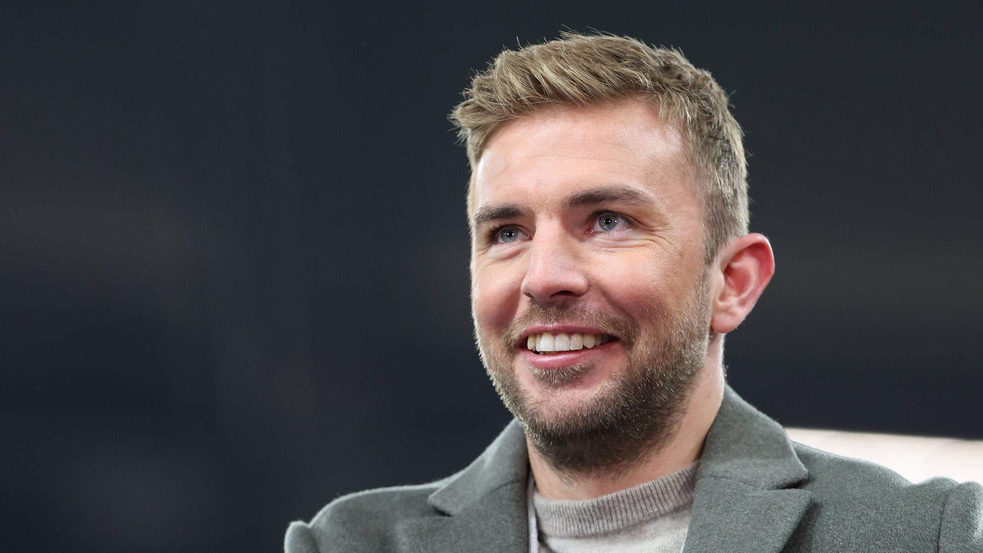 TV-Experte Christoph Kramer steht beim Champions-League-Spiel Schachtar Donezk gegen den FC Bayern München im Stadion und lächelt.