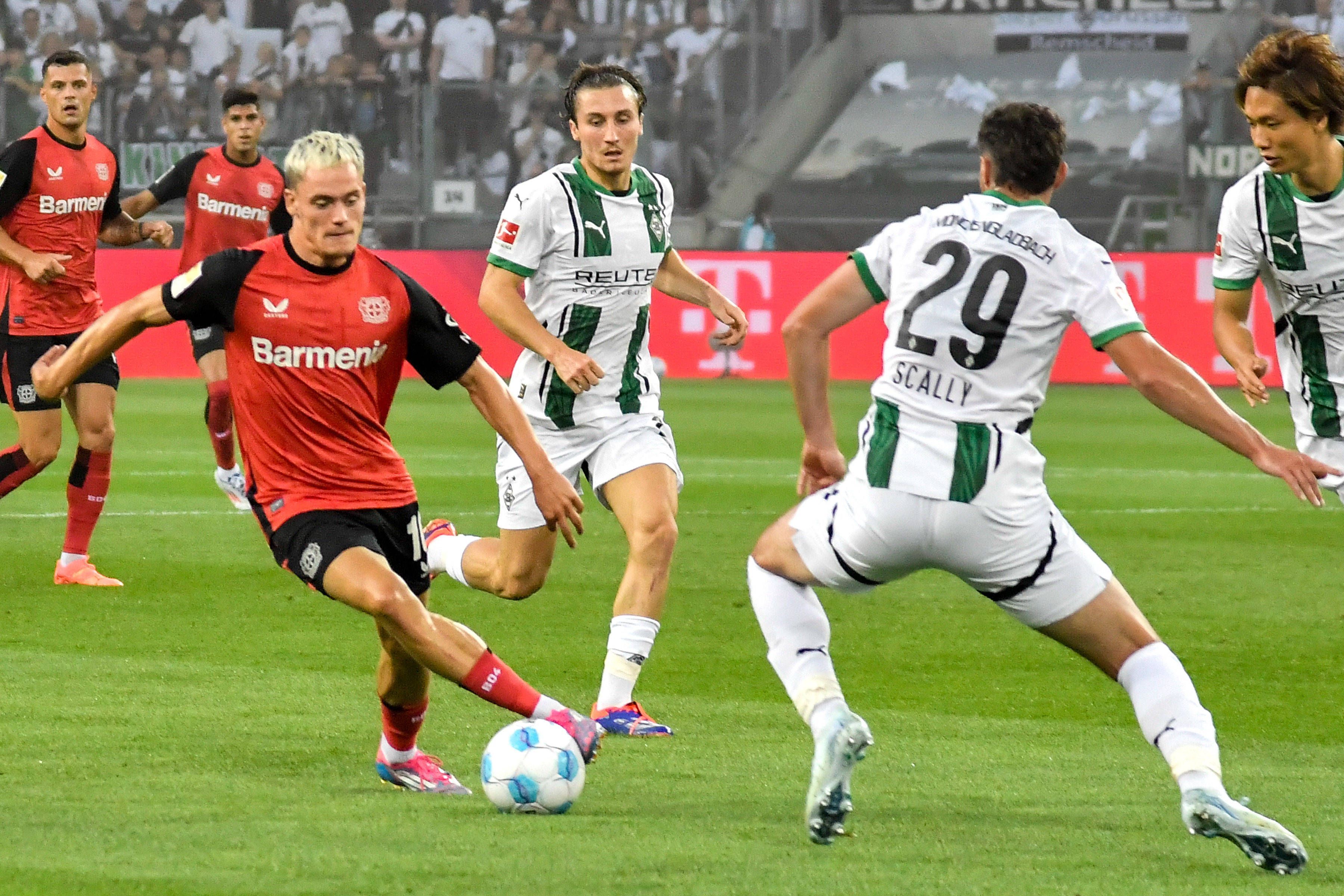 Spieler von Borussia Mönchengladbach im Kampf um den Ball gegen Florian Wirtz.