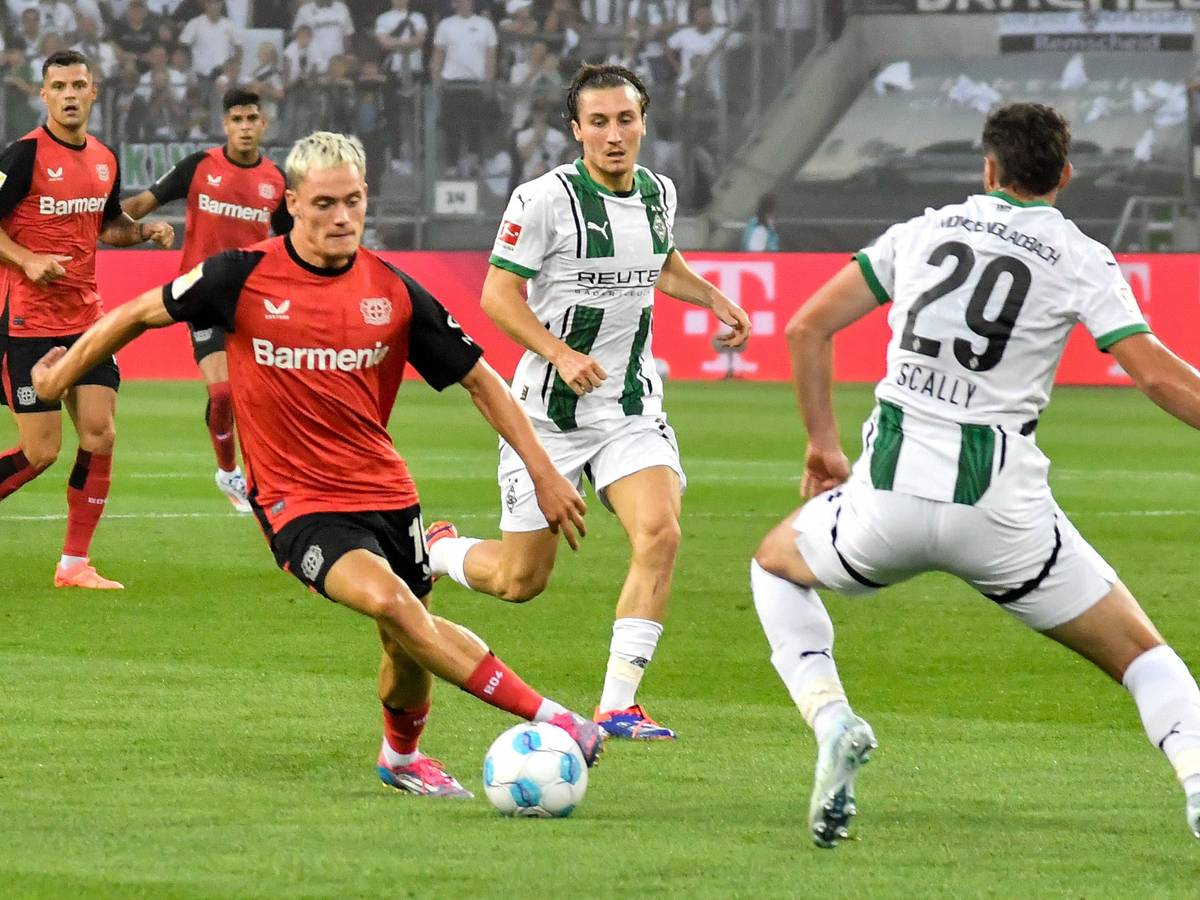 Spieler von Borussia Mönchengladbach im Kampf um den Ball gegen Florian Wirtz.