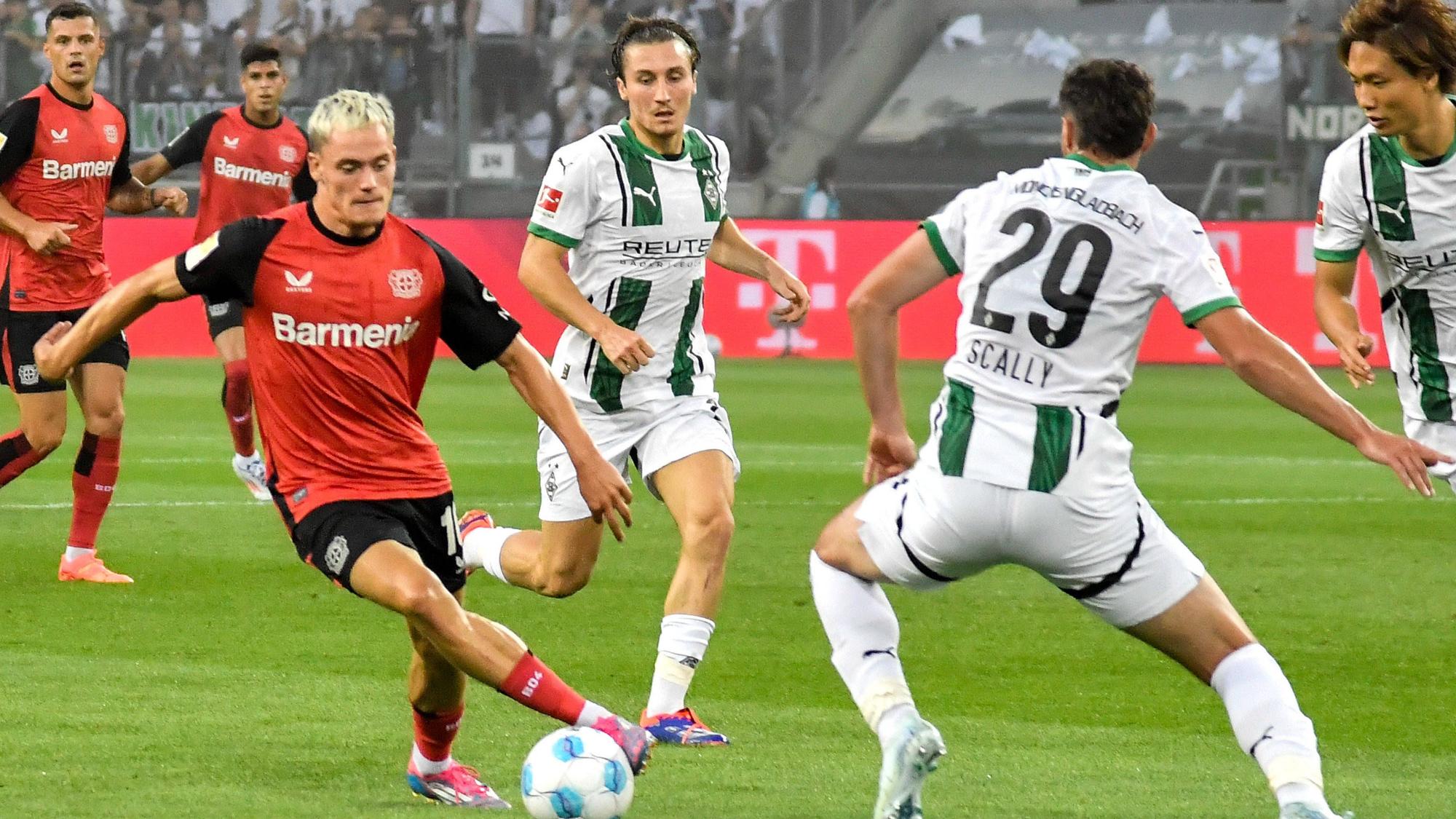 Spieler von Borussia Mönchengladbach im Kampf um den Ball gegen Florian Wirtz.