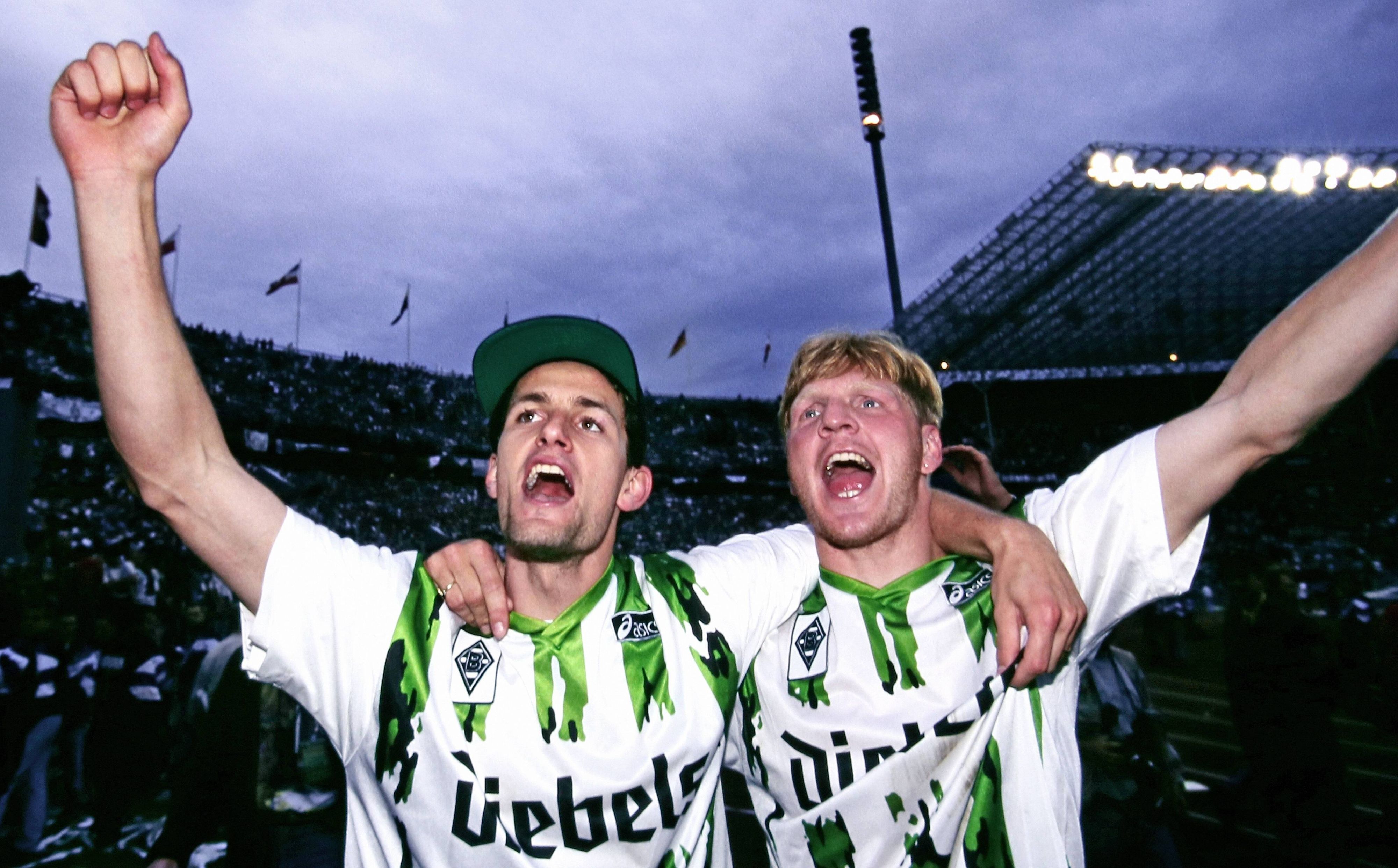 Heiko Herrlich und Stefan Effenberg jubeln nach dem Gewinn des DFB-Pokals mit Borussia Mönchengladbach Arm in Arm vor den Fans.