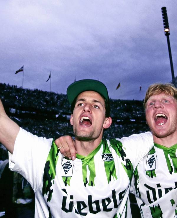 Heiko Herrlich und Stefan Effenberg jubeln nach dem Gewinn des DFB-Pokals mit Borussia Mönchengladbach Arm in Arm vor den Fans.