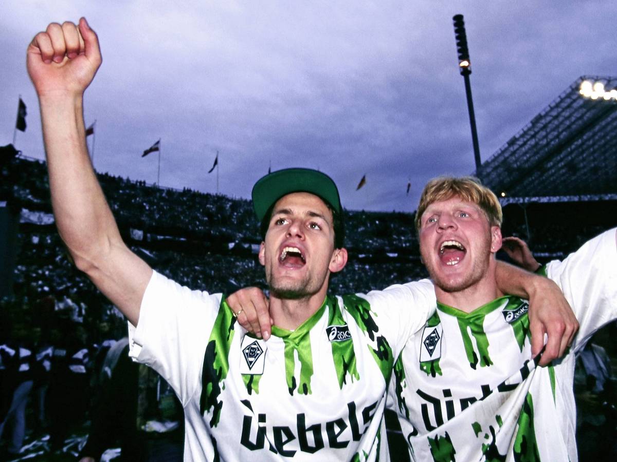 Heiko Herrlich und Stefan Effenberg jubeln nach dem Gewinn des DFB-Pokals mit Borussia Mönchengladbach Arm in Arm vor den Fans.