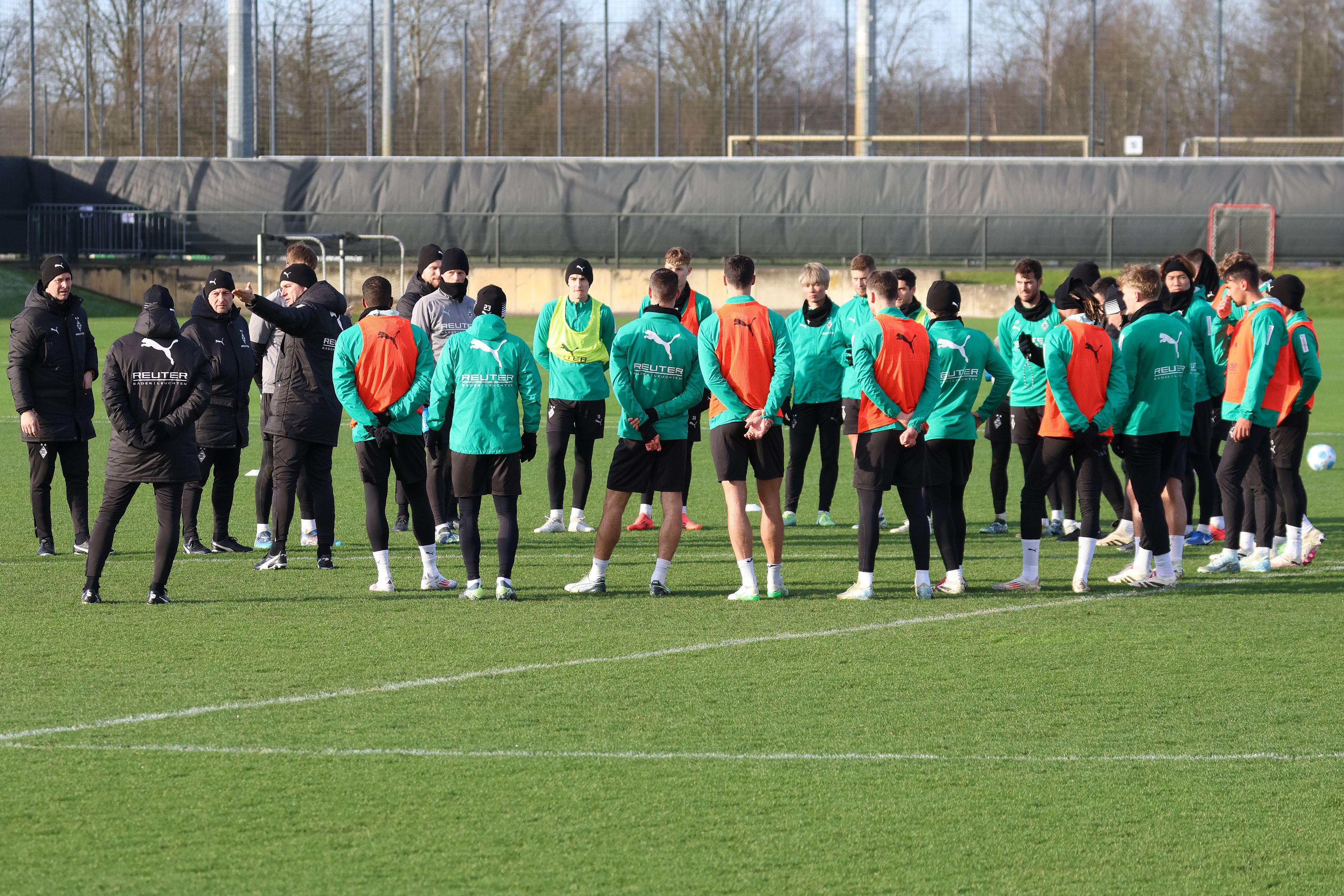 Borussia Mönchengladbachs Trainer Gerardo Seoane spricht beim Training zu seiner Mannschaft, die sich im Kreis aufgestellt hat.