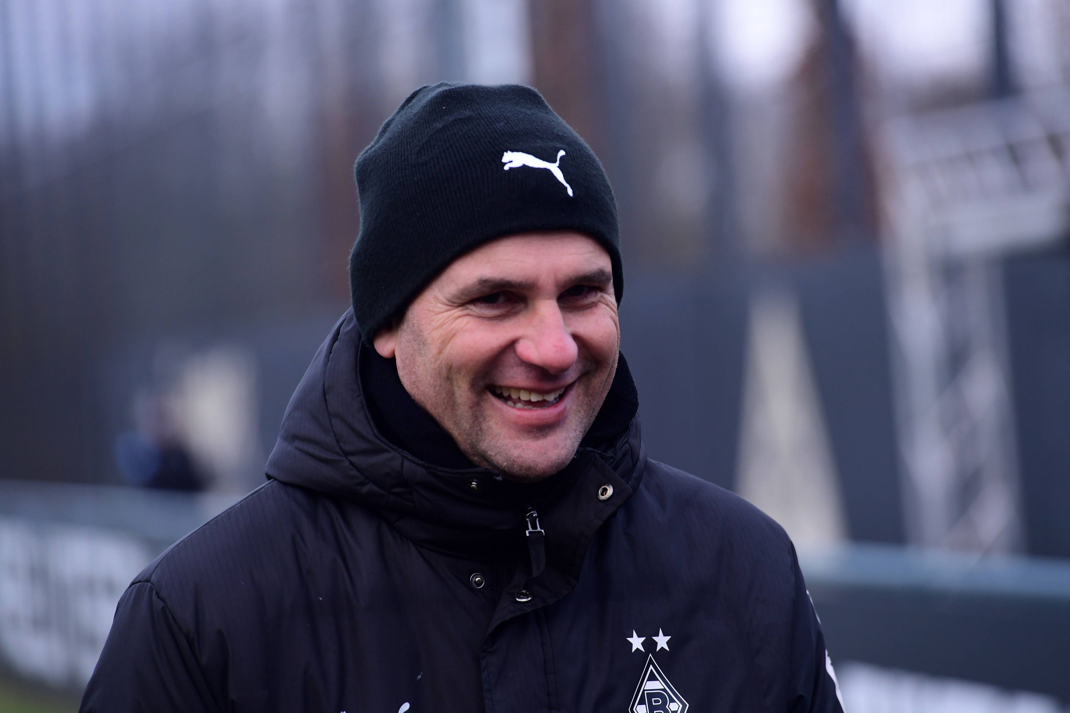 Borussia Mönchengladbachs Trainer Gerardo Seoane läuft lachend auf den Trainingsplatz.