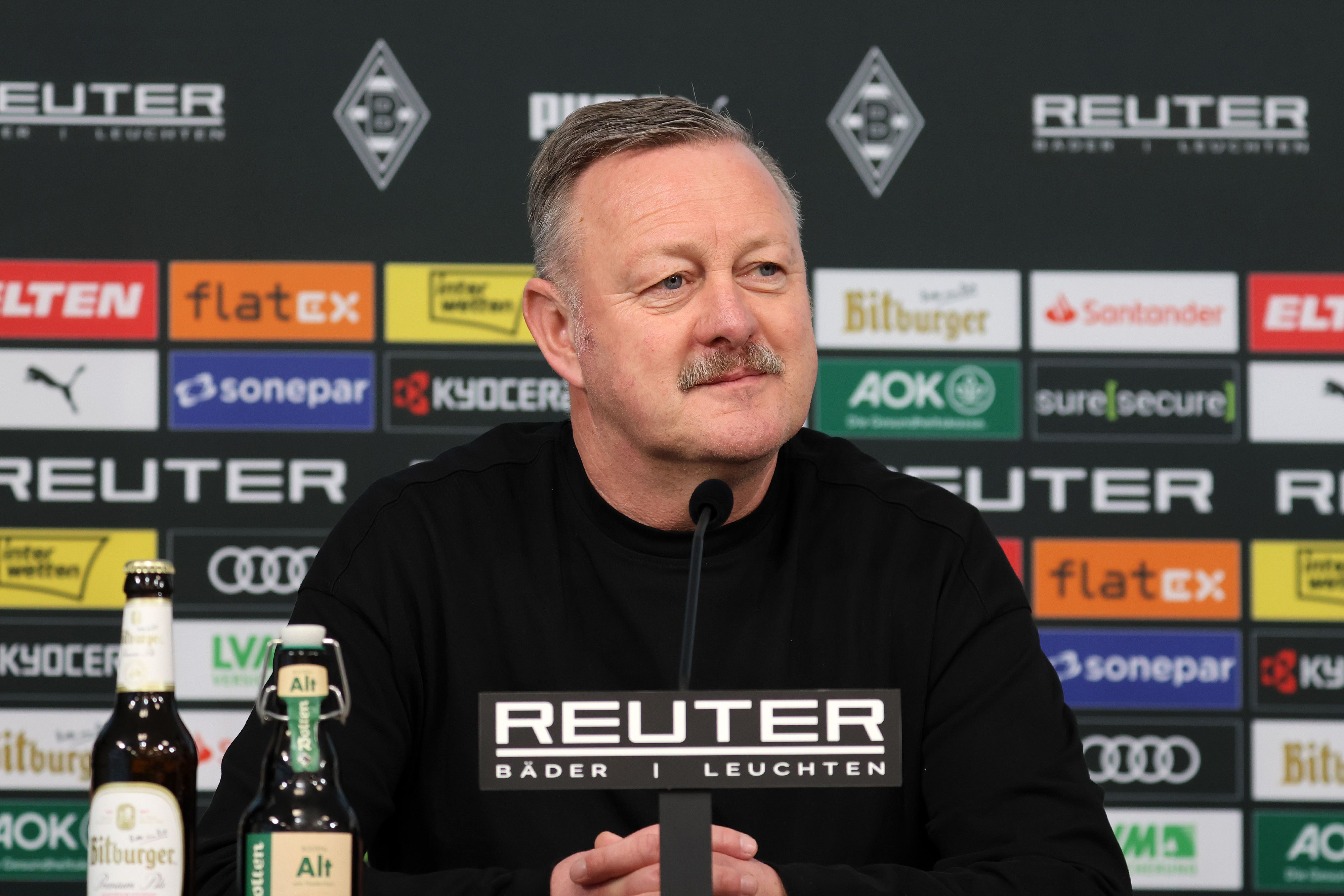 Borussia Mönchengladbachs Sport-Geschäftsführer Roland Virkus sitzt bei einer Pressekonferenz auf dem Podium.