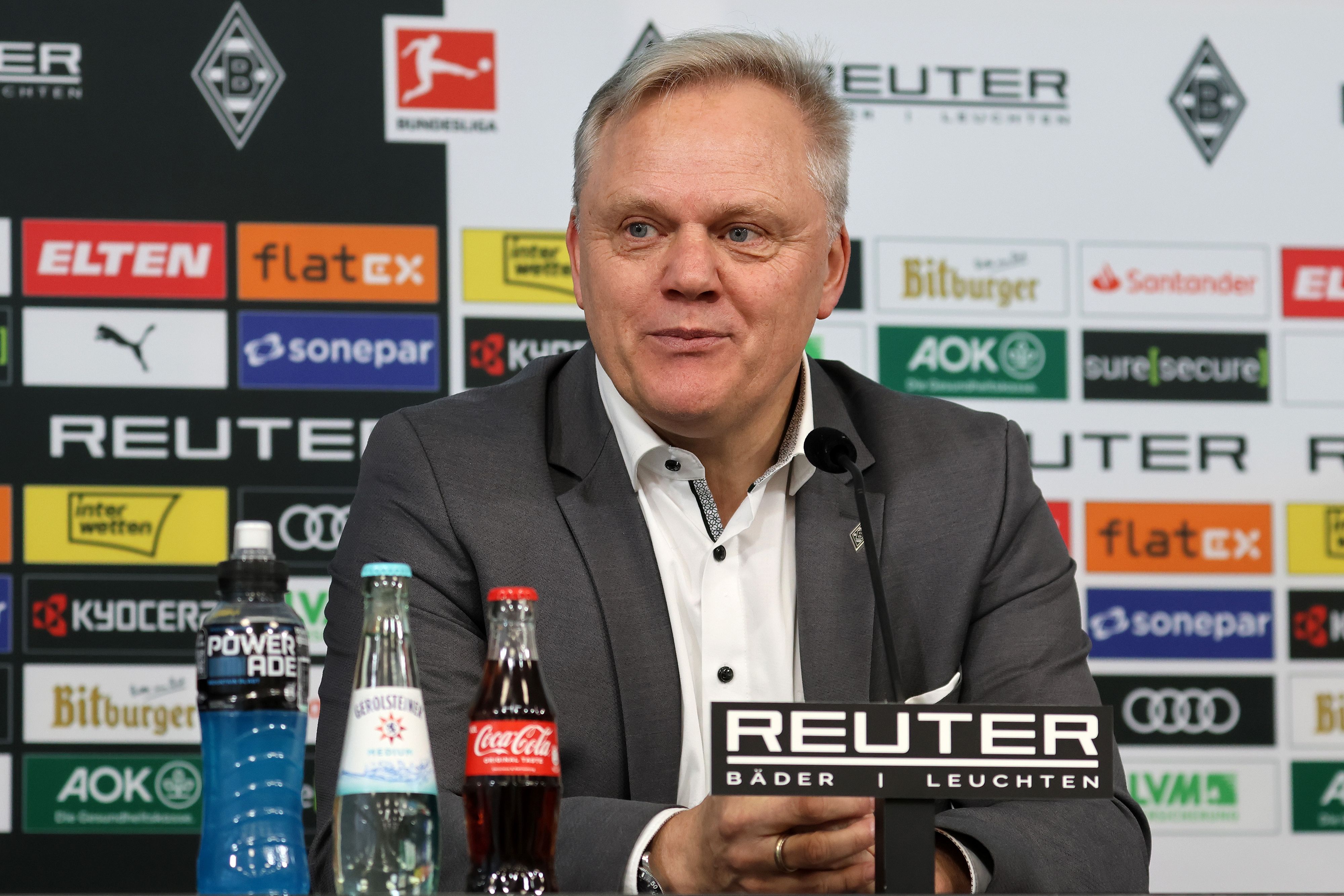 Borussia Mönchengladbachs neuer CEO Stefan Stegemann sitzt bei seiner Vorstellung auf dem Podium und lauscht einer Frage.