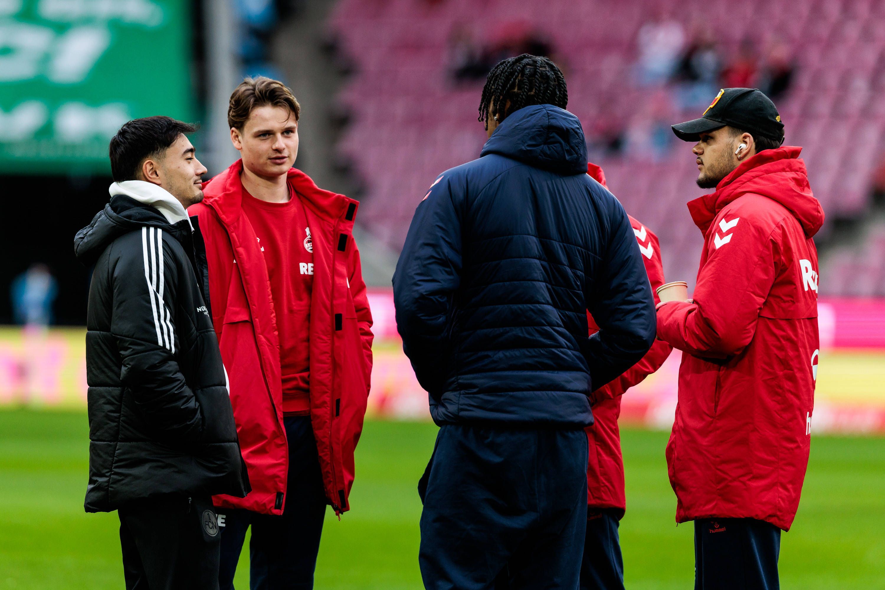 Die FC-Profis Jonas Urbig, Damion Downs und Max Finkgräfe sprechen mit Jens Castrop (l.).