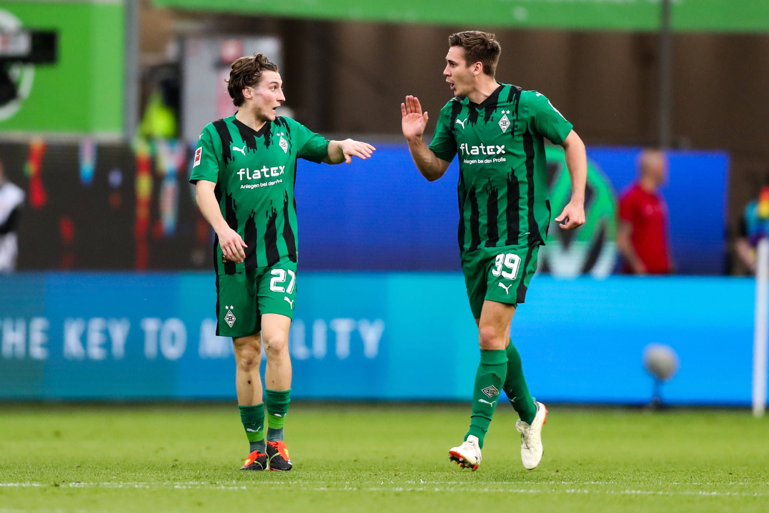 Die Gladbach-Profis Rocco Reitz und Maximilian Wöber klatschen sich im Bundesliga-Spiel beim VfL Wolfsburg ab.