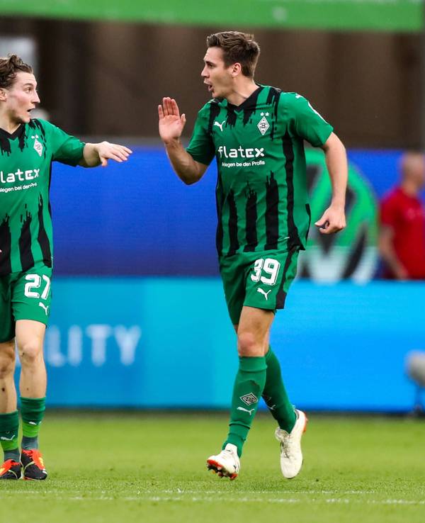 Die Gladbach-Profis Rocco Reitz und Maximilian Wöber klatschen sich im Bundesliga-Spiel beim VfL Wolfsburg ab.