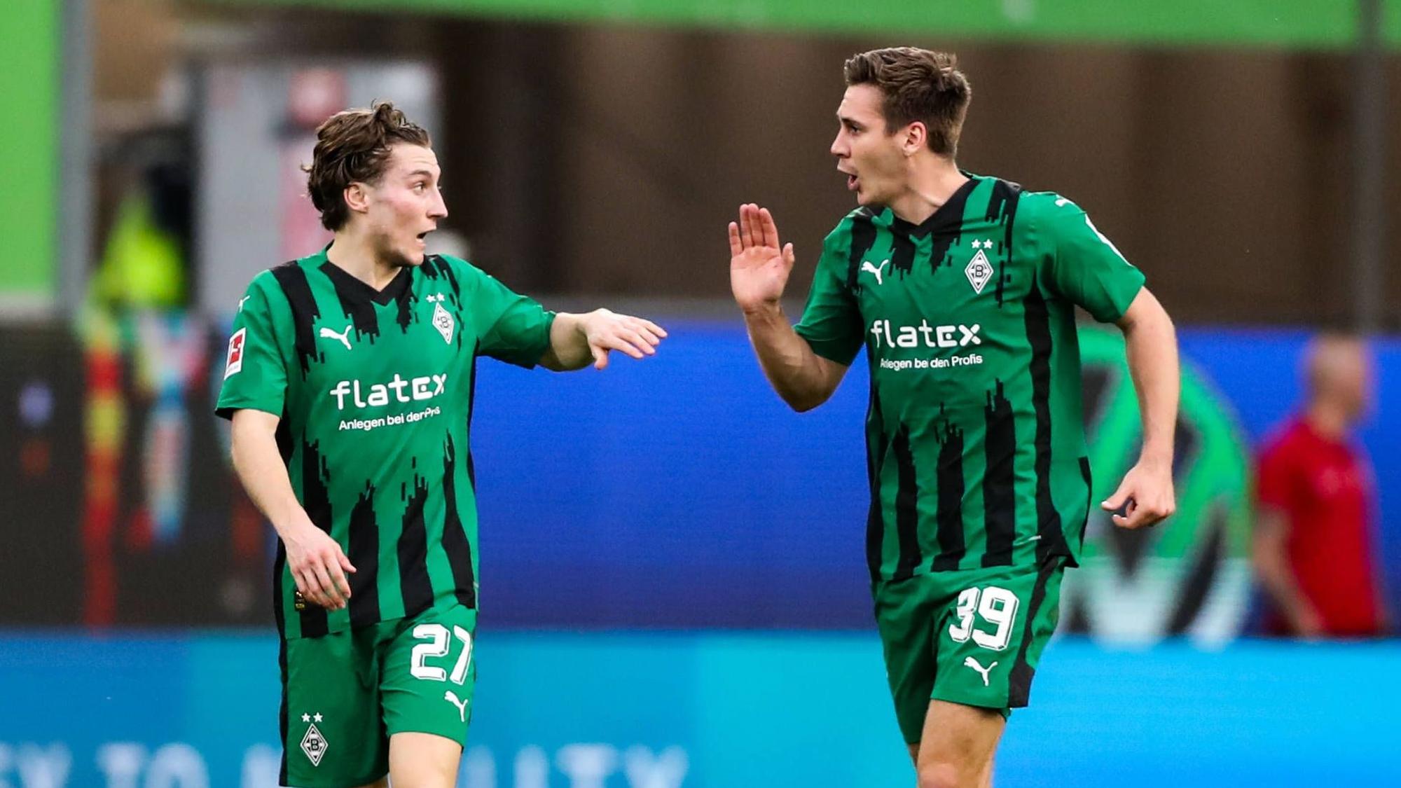 Die Gladbach-Profis Rocco Reitz und Maximilian Wöber klatschen sich im Bundesliga-Spiel beim VfL Wolfsburg ab.