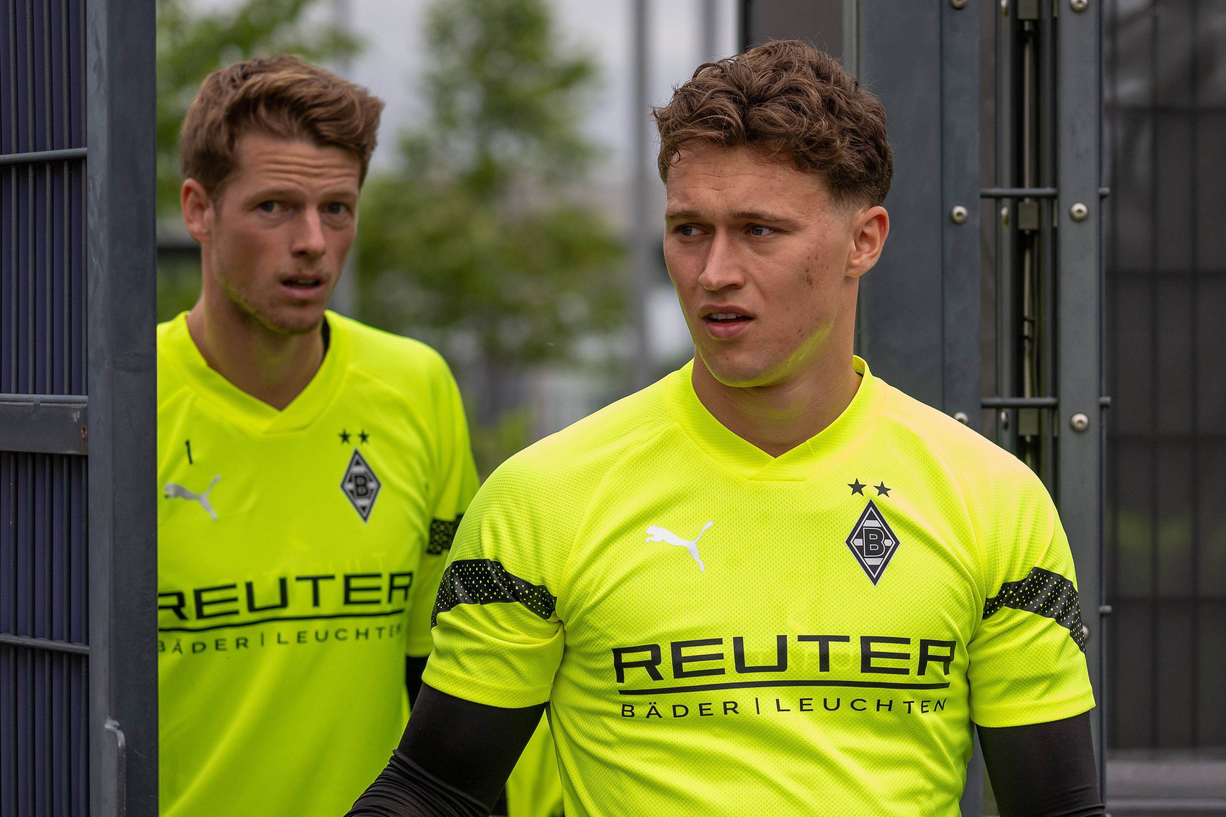 Die Gladbach-Keeper Jan Olschowsky und Jonas Omlin laufen hintereinander auf den Trainingsplatz.
