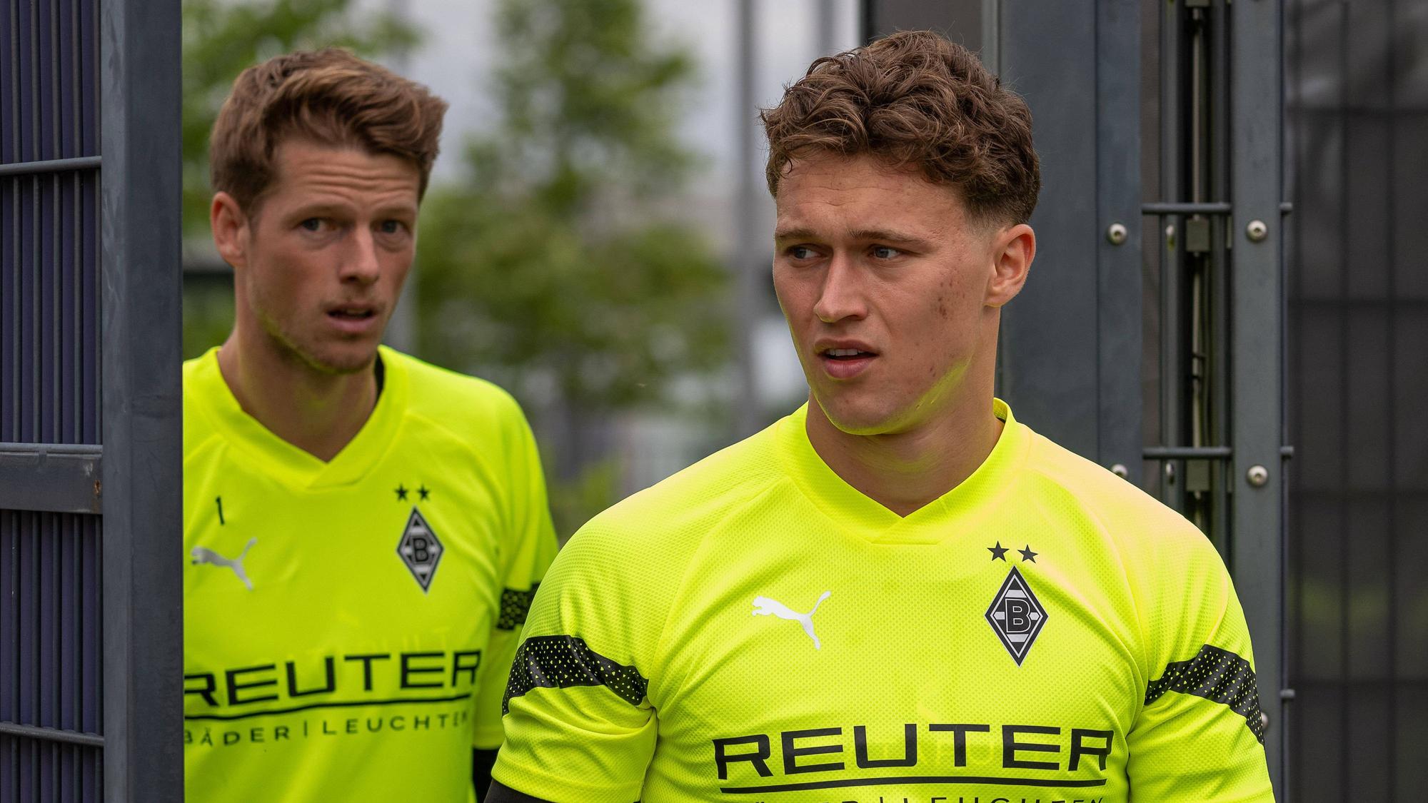 Die Gladbach-Keeper Jan Olschowsky und Jonas Omlin laufen hintereinander auf den Trainingsplatz.