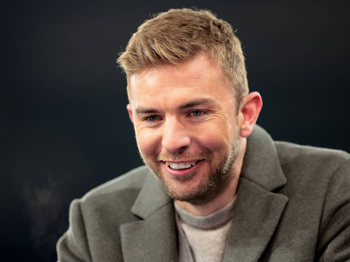 Experte Christoph Kramer steht beim Champions-League-Spiel Schachtar Donezk gegen den FC Bayern München lachend am Moderatorenpult.