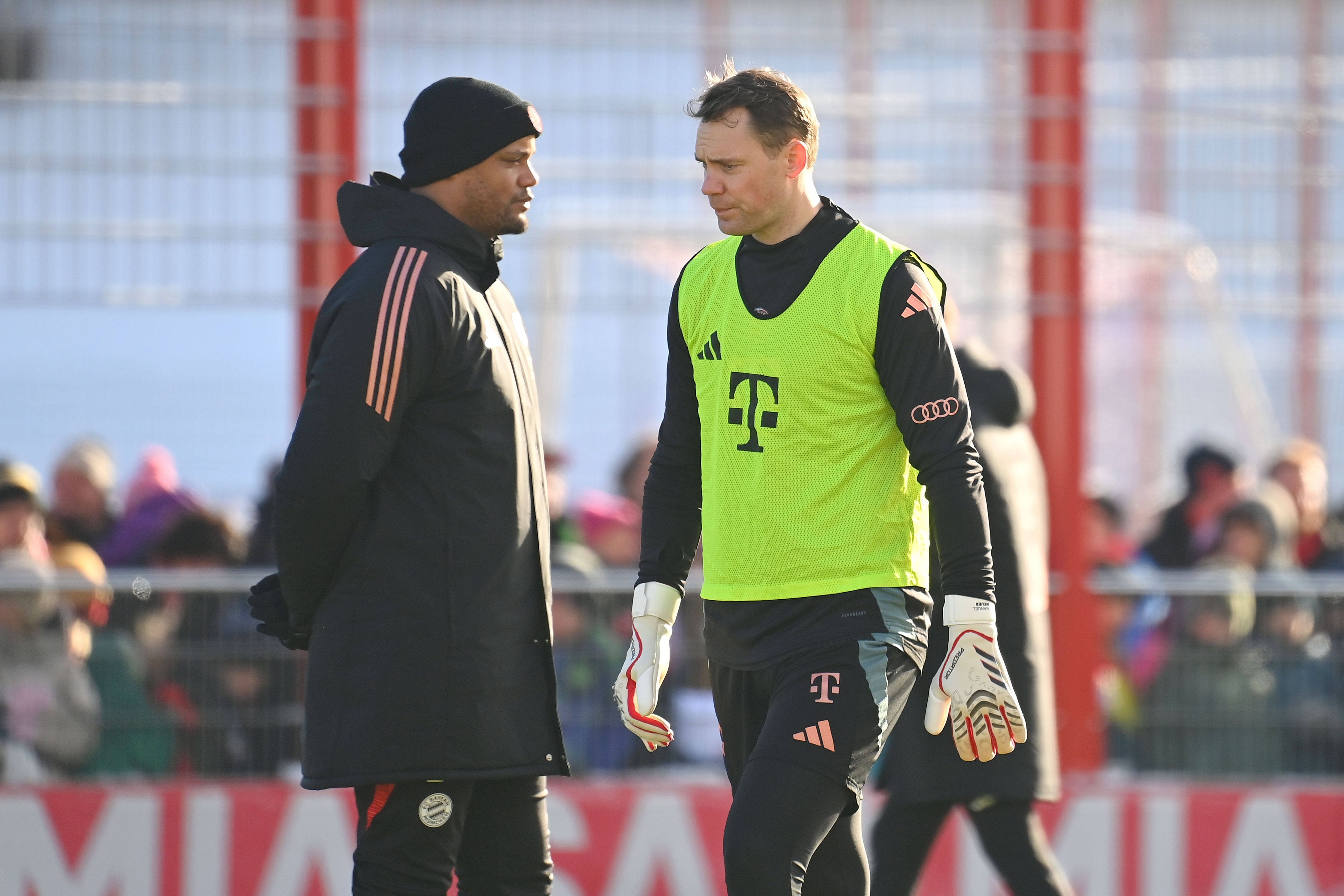 Bayern Münchens Trainer Vincent Kompany und Torwart Manuel Neuer stehen nebeneinander auf dem Trainingsplatz.