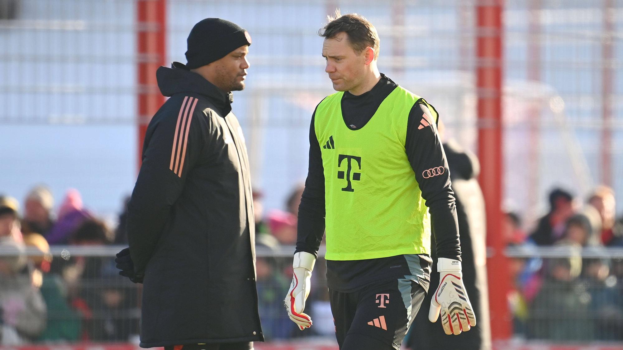 Bayern Münchens Trainer Vincent Kompany und Torwart Manuel Neuer stehen nebeneinander auf dem Trainingsplatz.