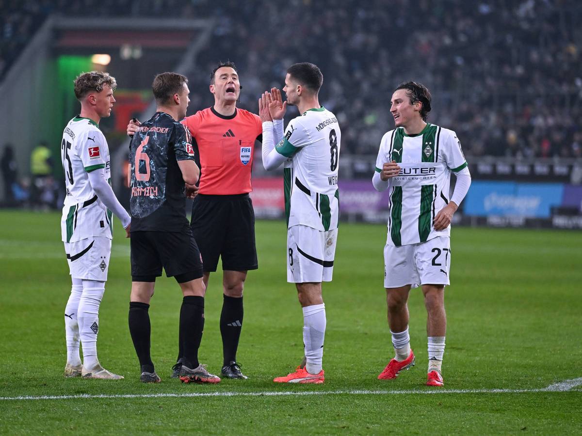 Felix Zwayer erklärt drei Gladbachern und einem Bayern-Spieler eine Entscheidung.