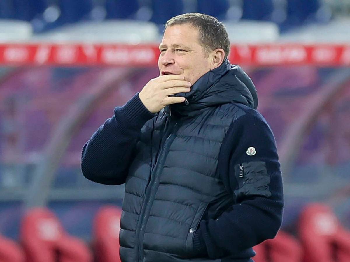 Bayern Münchens Sport-Vorstand Max Eberl steht beim Testspiel in Salzburg lächelnd im Stadion und legt die Hand vor den Mund.