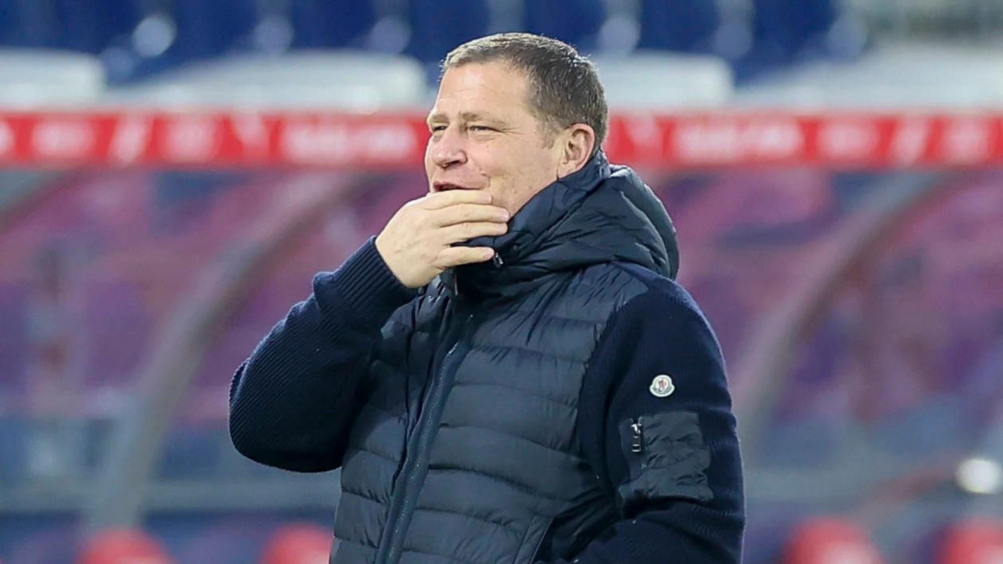 Bayern Münchens Sport-Vorstand Max Eberl steht beim Testspiel in Salzburg lächelnd im Stadion und legt die Hand vor den Mund.
