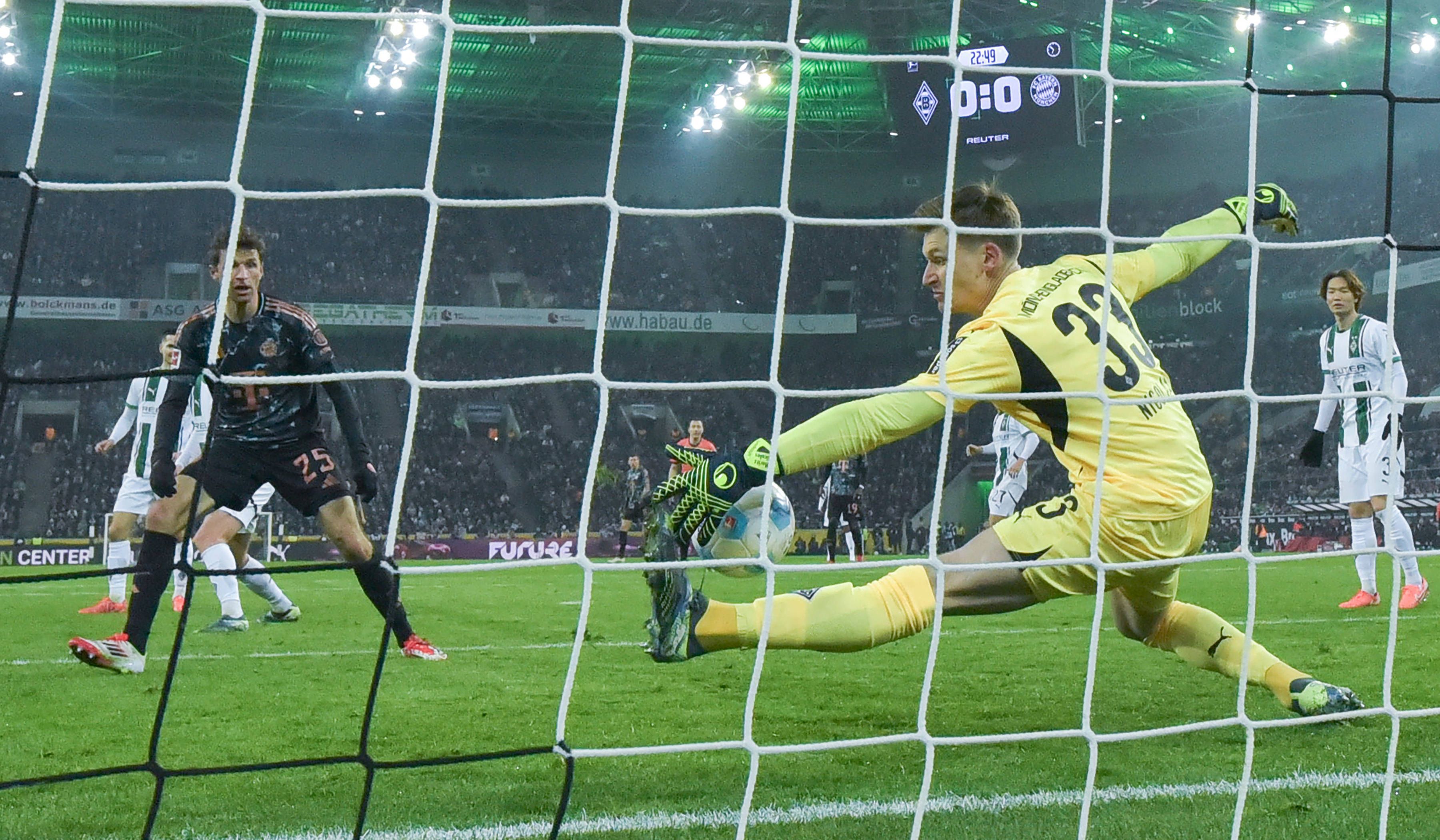 Borussia Mönchengladbachs Keeper Moritz Nicolas pariert einen Schuss von Bayern Münchens Thomas Müller mit der linken Hand.