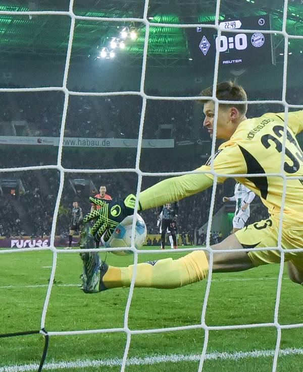 Borussia Mönchengladbachs Keeper Moritz Nicolas pariert einen Schuss von Bayern Münchens Thomas Müller mit der linken Hand.