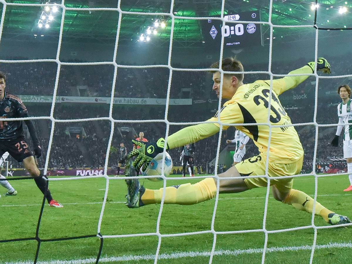 Borussia Mönchengladbachs Keeper Moritz Nicolas pariert einen Schuss von Bayern Münchens Thomas Müller mit der linken Hand.