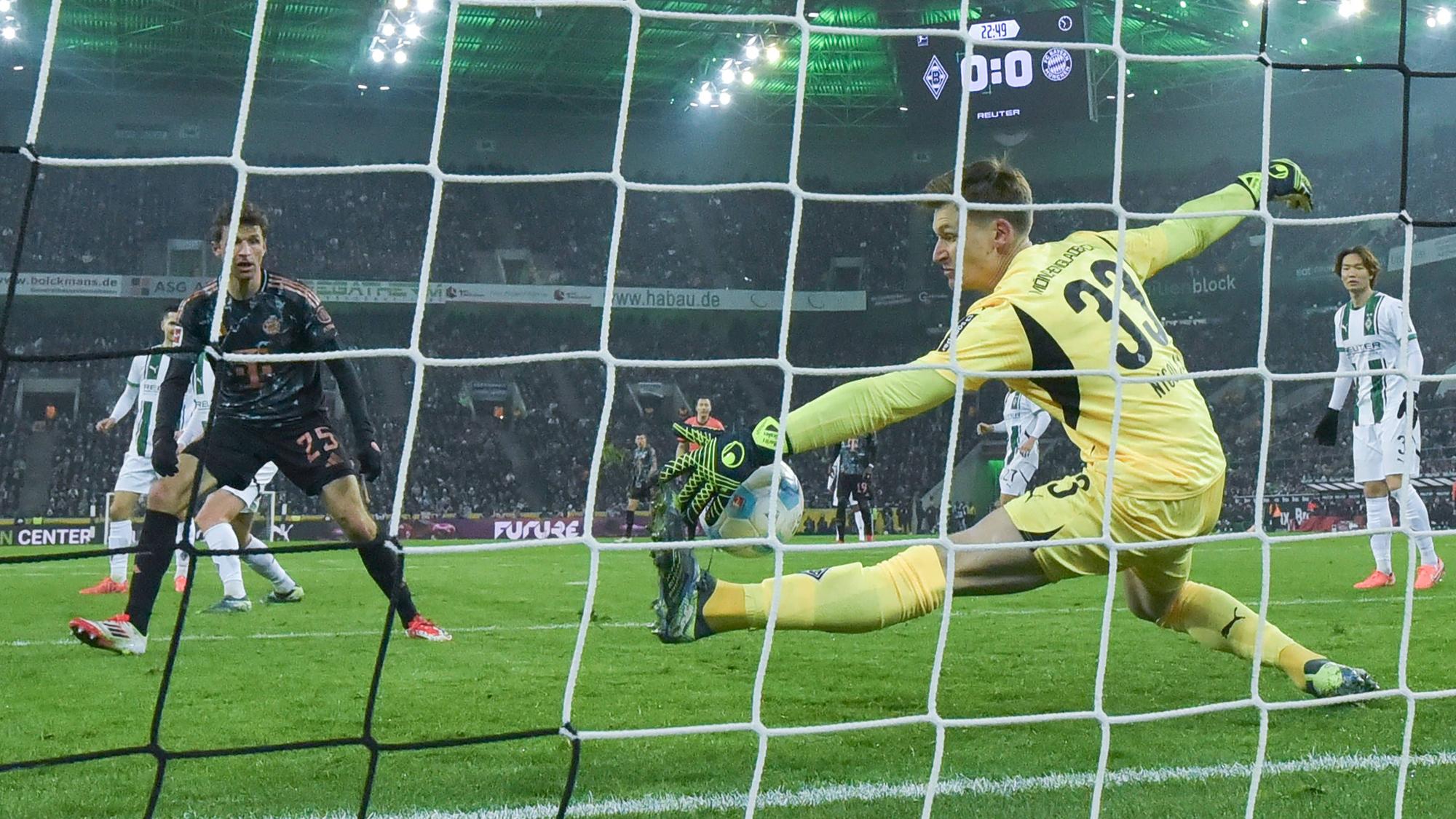 Borussia Mönchengladbachs Keeper Moritz Nicolas pariert einen Schuss von Bayern Münchens Thomas Müller mit der linken Hand.