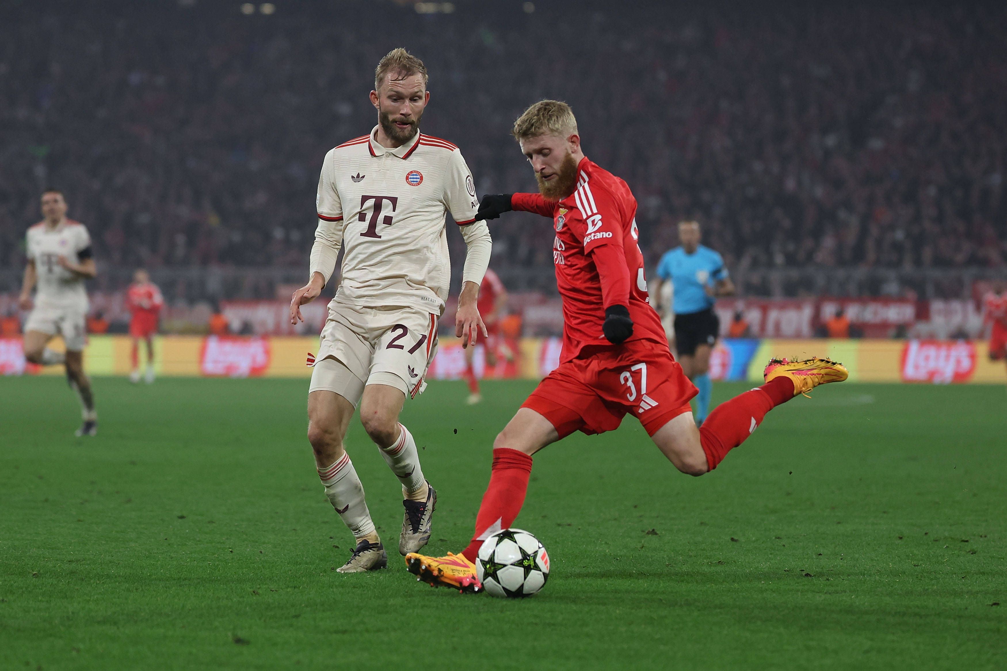 Jan-Niklas Beste schlägt im Benfica-Trikot eine Flanke. Konrad Laimer vom FC Bayern München kann nur zuschauen.