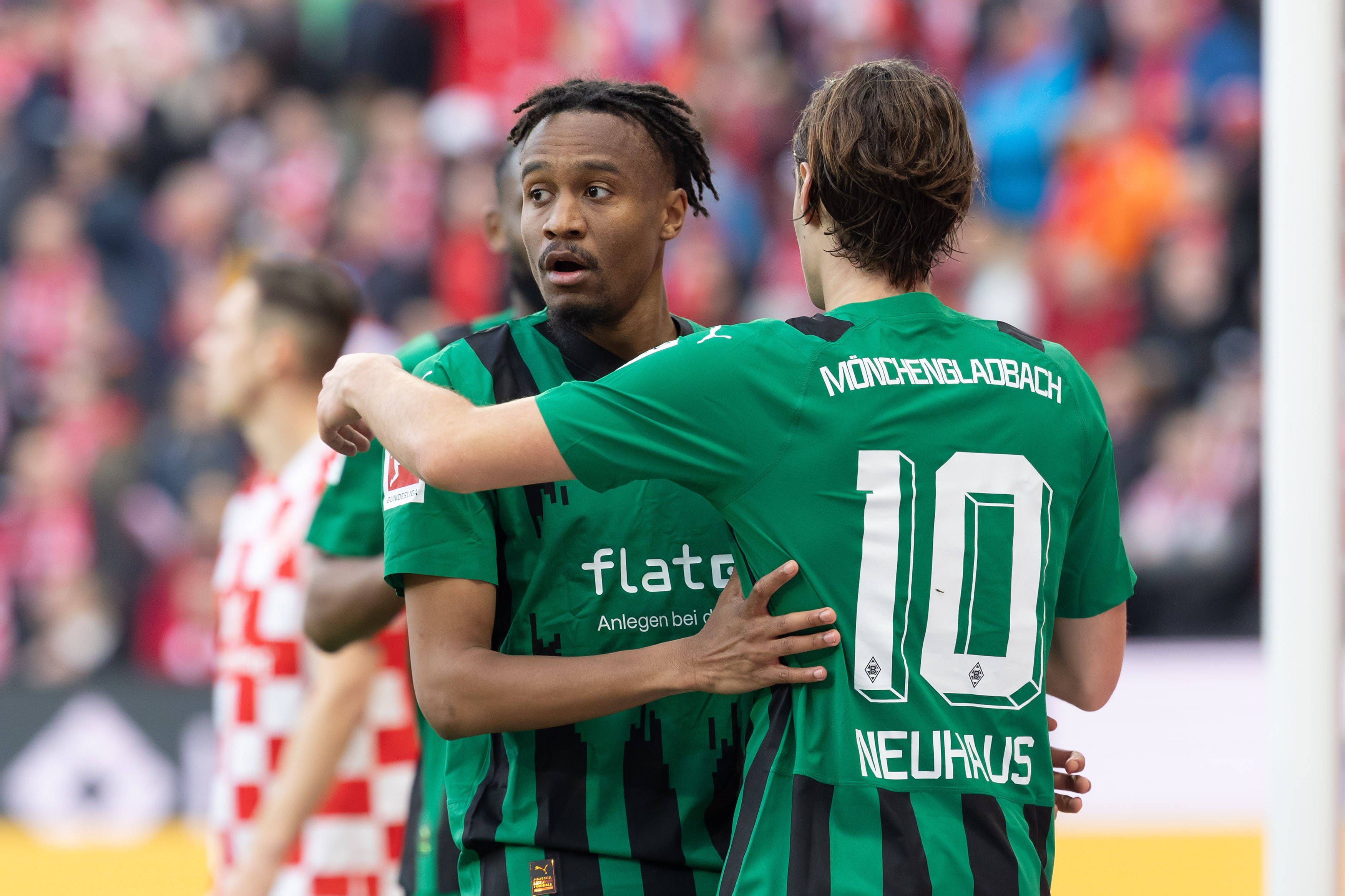 Nathan Ngoumou und Florian Neuhaus umarmen sich.