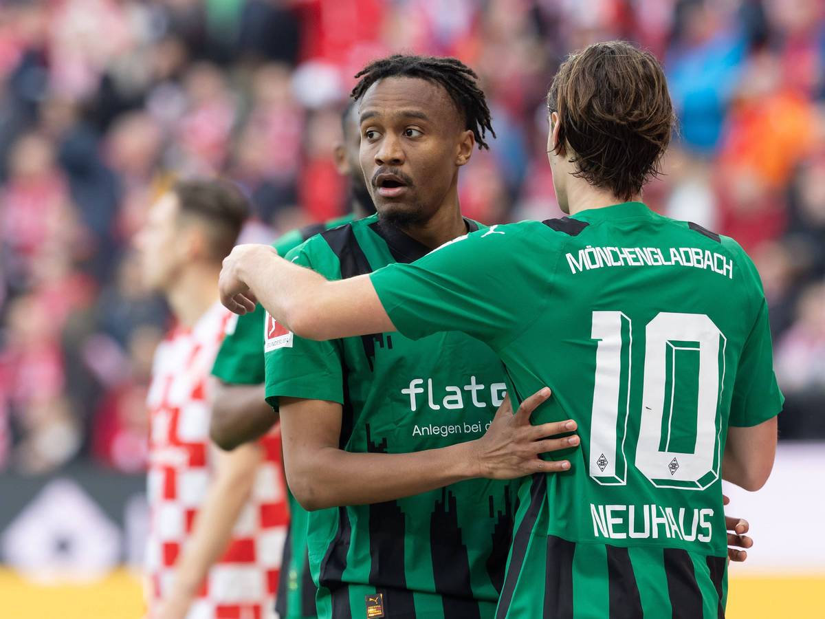 Nathan Ngoumou und Florian Neuhaus umarmen sich.