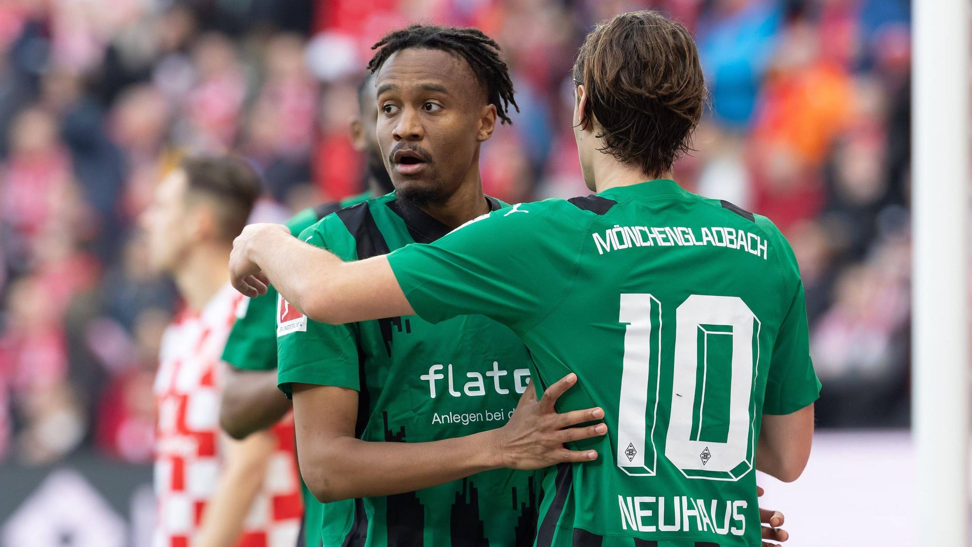 Nathan Ngoumou und Florian Neuhaus umarmen sich.